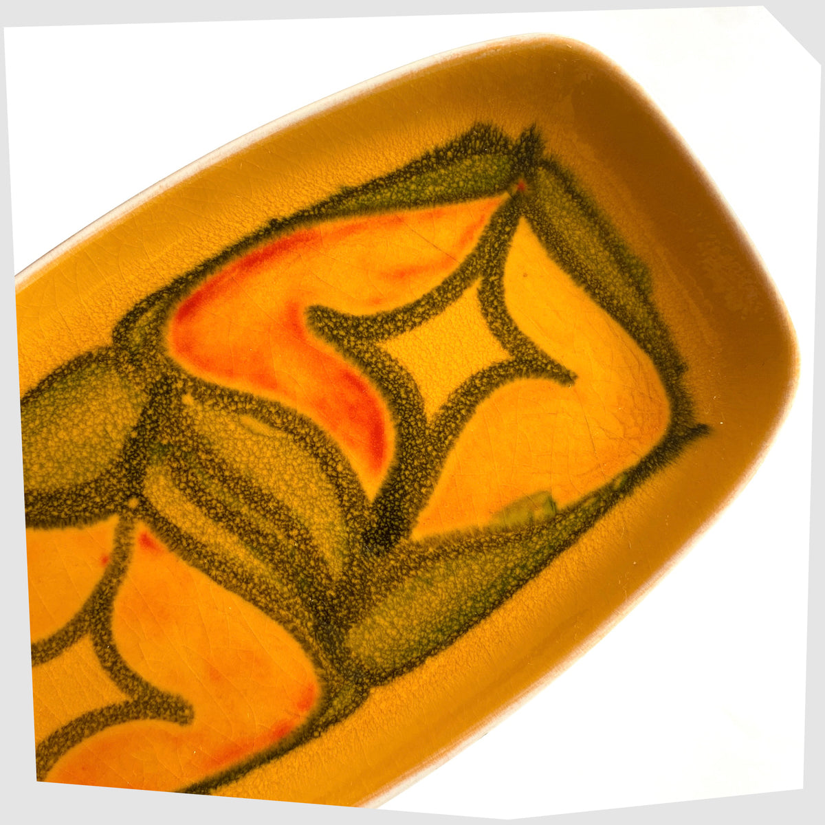 Close up of the Poole Pottery Delphis Pin Dish, Shape 361, by Lynn Gregory in a vibrant yellow glaze with free-form shapes of orange and green, shown on a white background