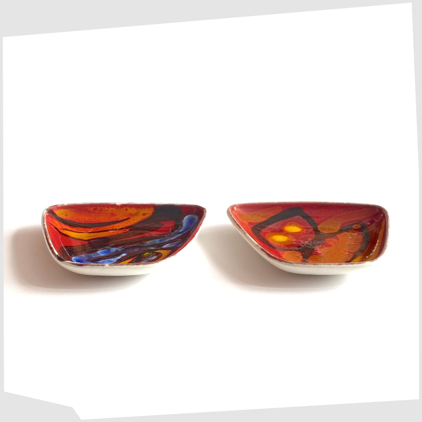 set of two Poole Pottery Delphis Pin Dish, shape 41, by Loretta Leigh glazed in a rich red with fluid forms of blue, orange and yellow