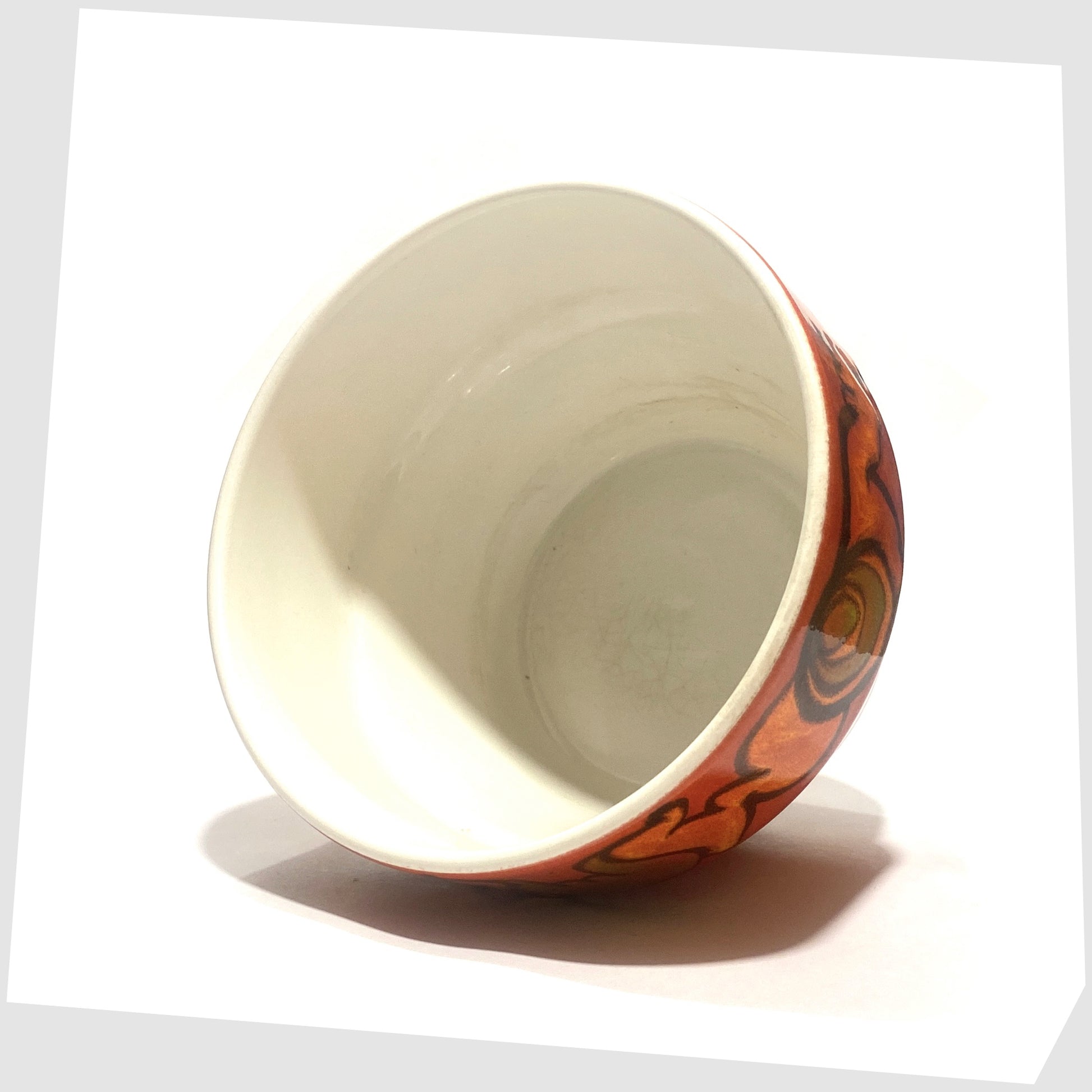 inner white glaze of the poole pottery planter finished in a rich red glaze with orange and green forms around the rim