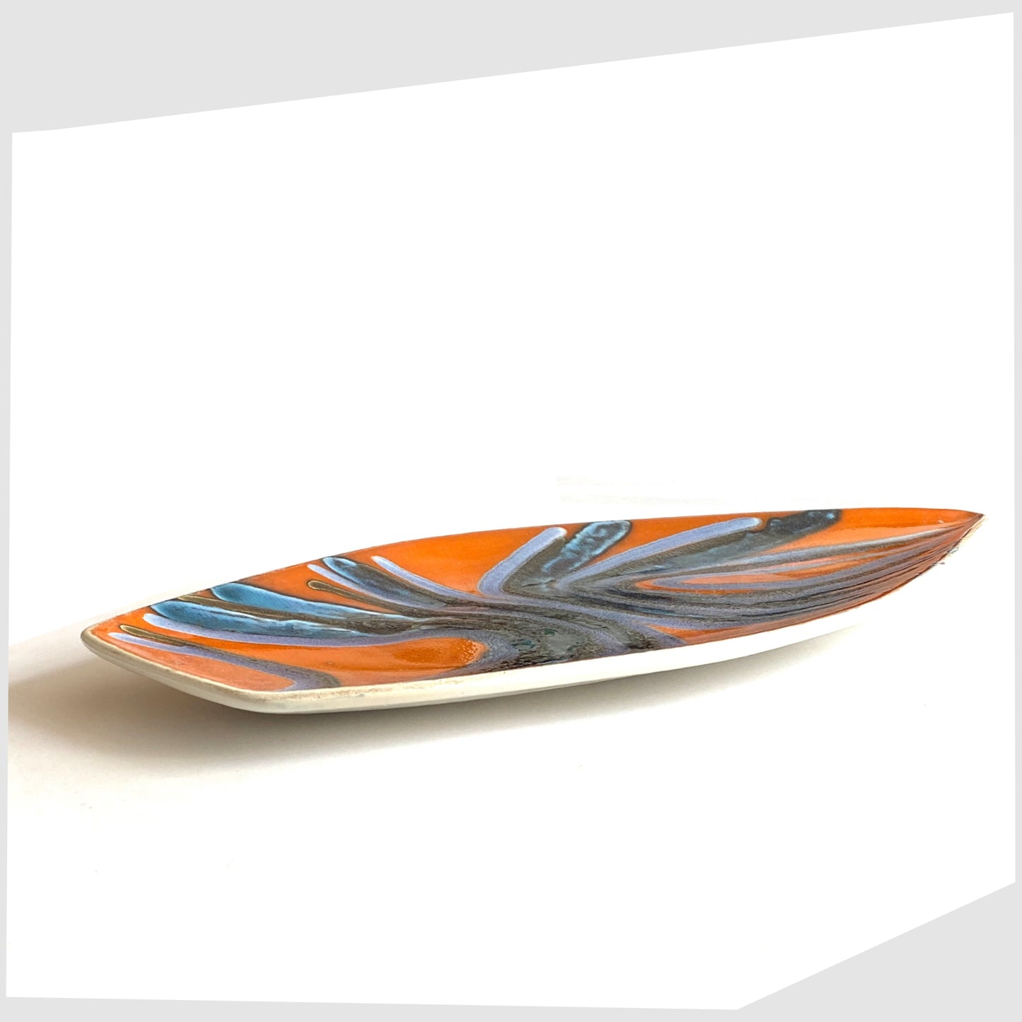 side profile of the Poole Pottery Delphis Spear Dish by Margaret Anderson in a fiery orange glaze with radiating lines of blue and purple glaze