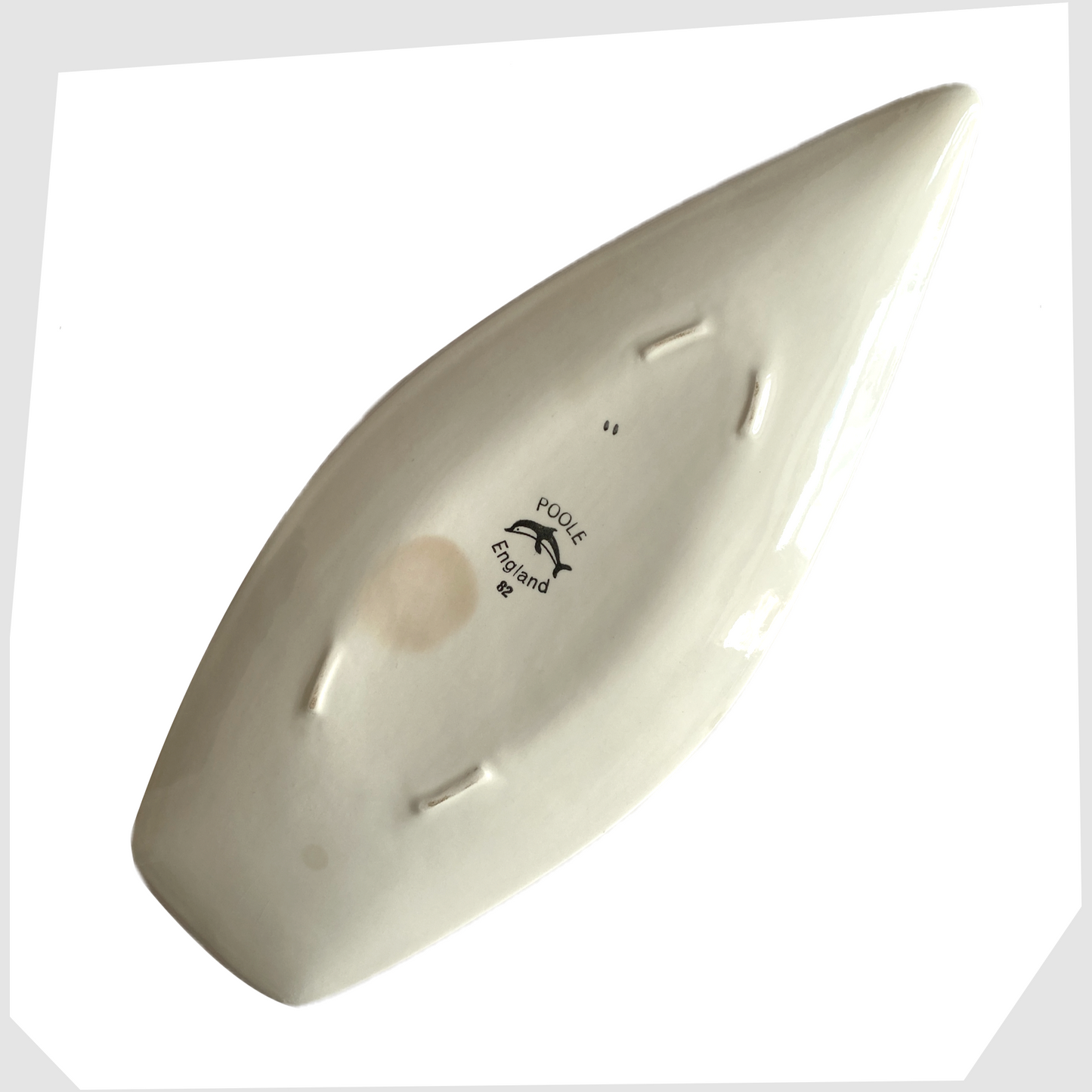 Rear of the Poole Pottery Delphis Spear Dish marked with the Poole dolphin logo, model 82 and hand-signed as II for Margaret Anderson 