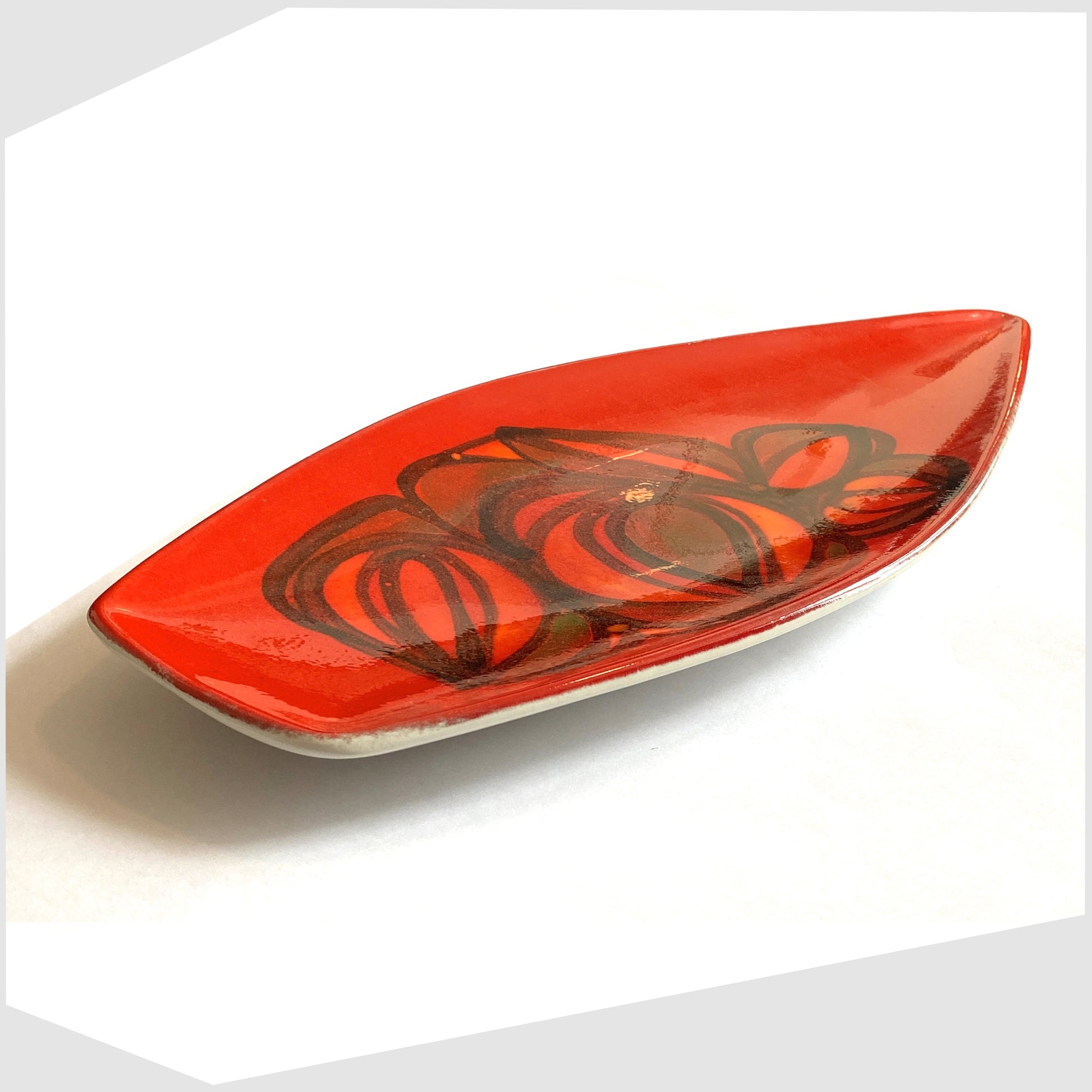 side profile of the vintage Poole Pottery Spear Dish in a red Delphis glaze with free-form shapes in orange and green