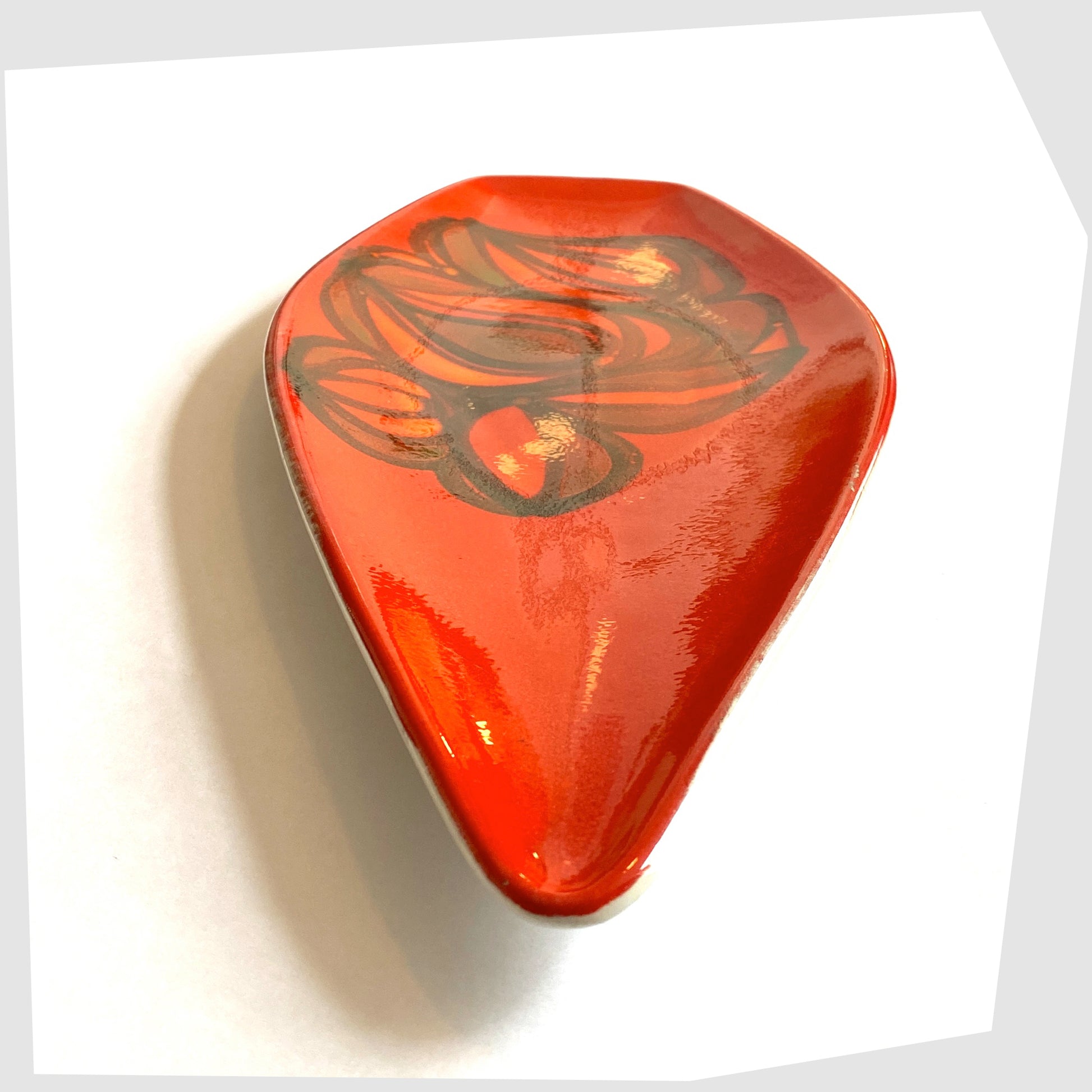 front tip of the Poole Pottery Spear Dish in a red Delphis glaze with free-form shapes in orange and green