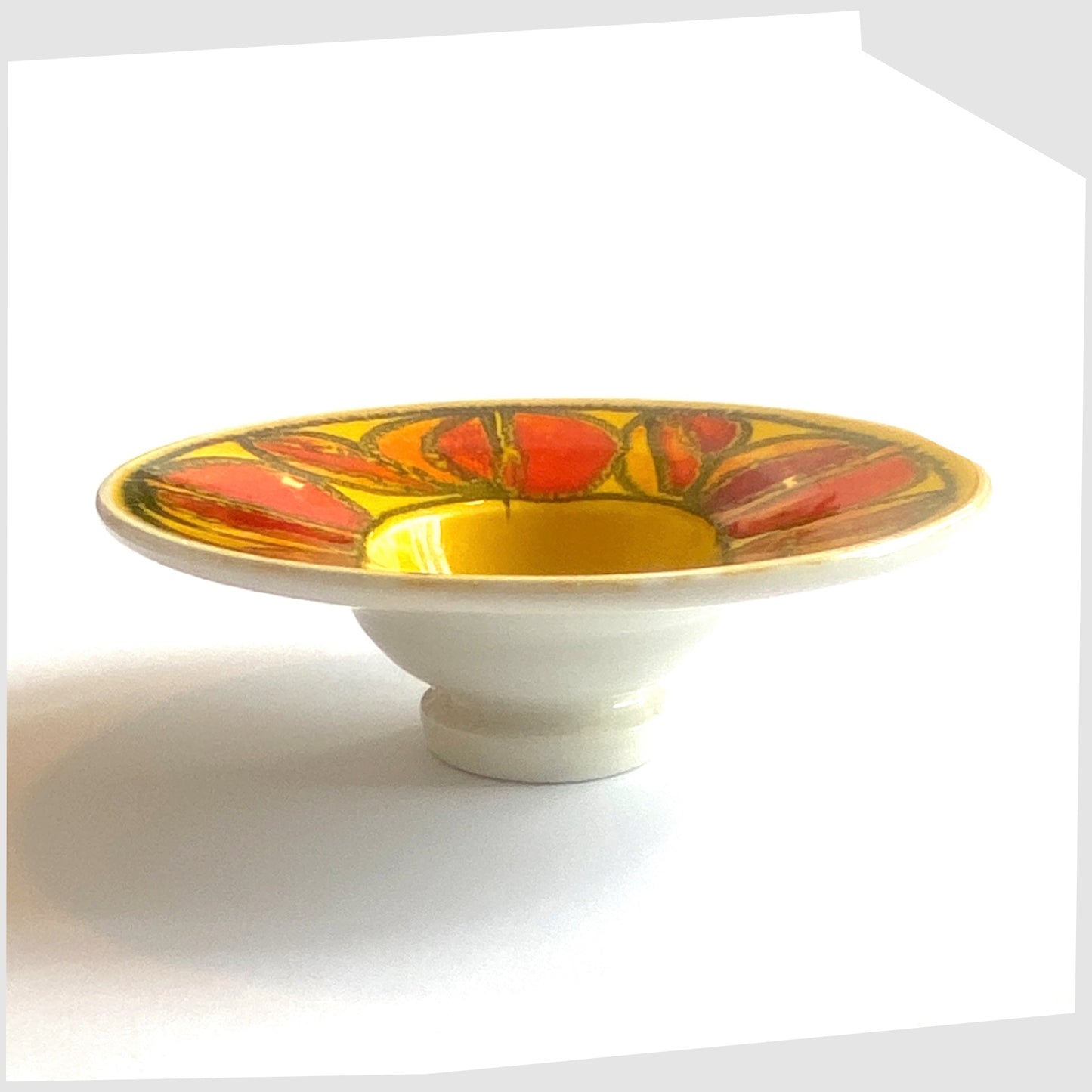 poole pottery delphis candleholder in a vivid yellow with circular forms of red and orange glaze