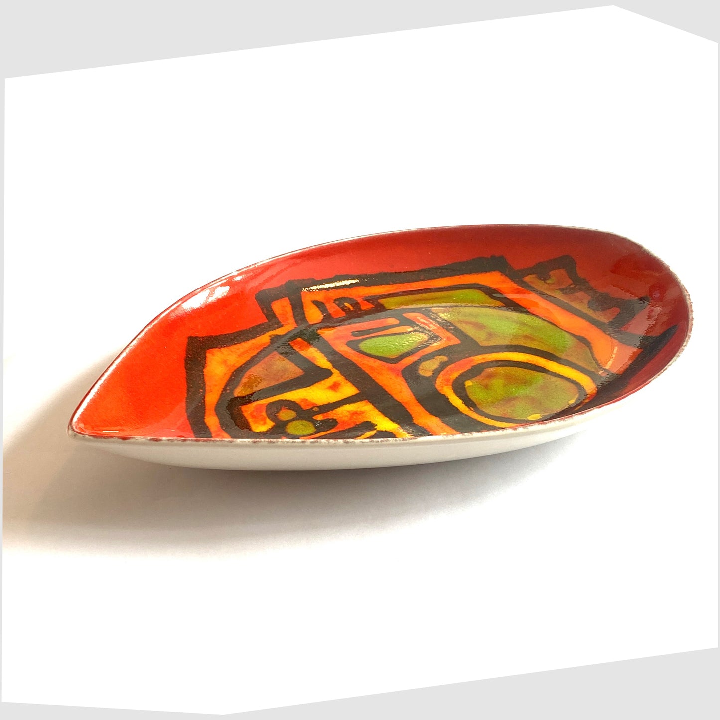 poole pottery delphis teardrop dish, shape 91, designed by Carol Cutler. Teardrop-shaped ceramic plate in a red delphis glaze with green and orange abstract form