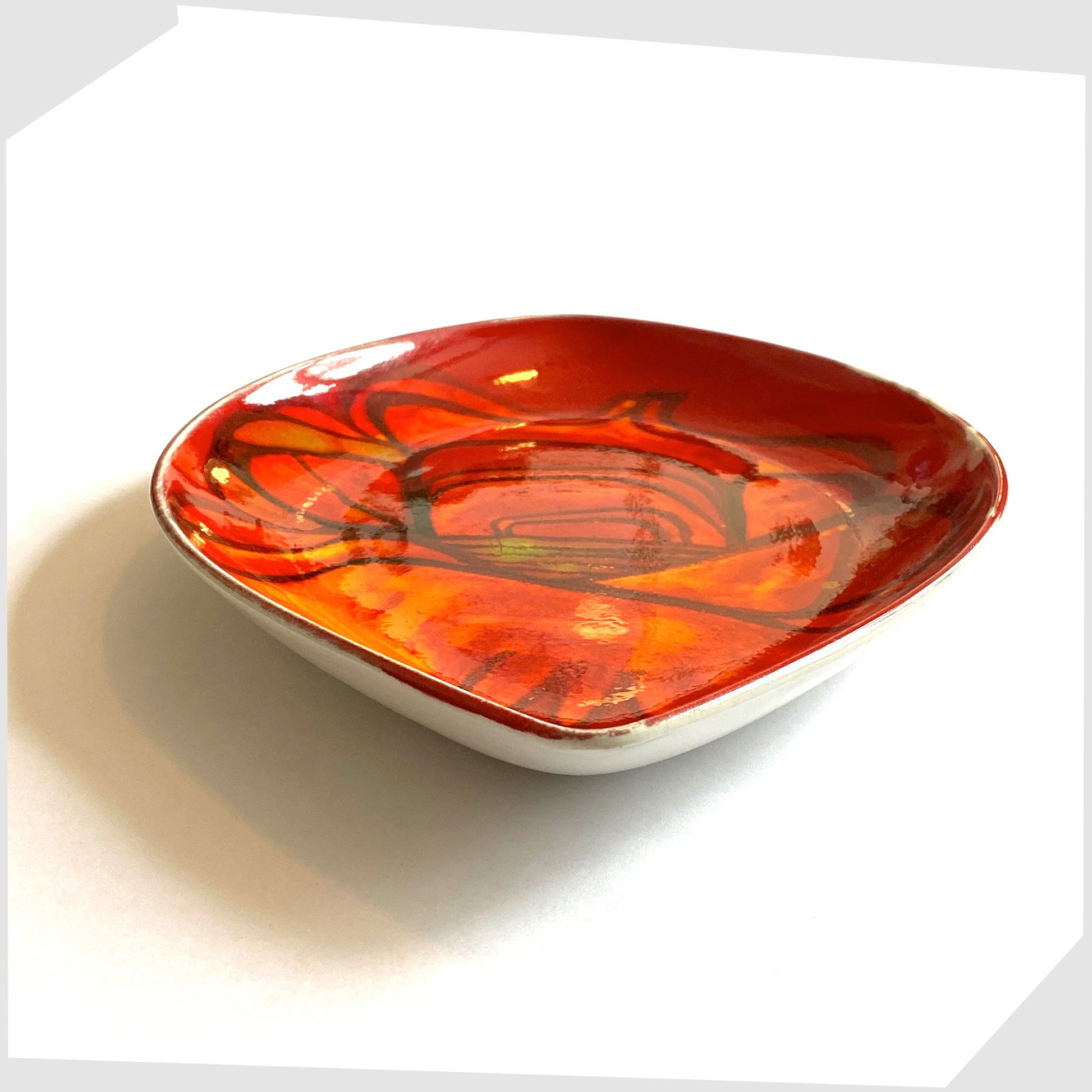 side profile of the poole pottery delphis teardrop dish by Lynn Gregory, finished in a rich red with orange and green forms