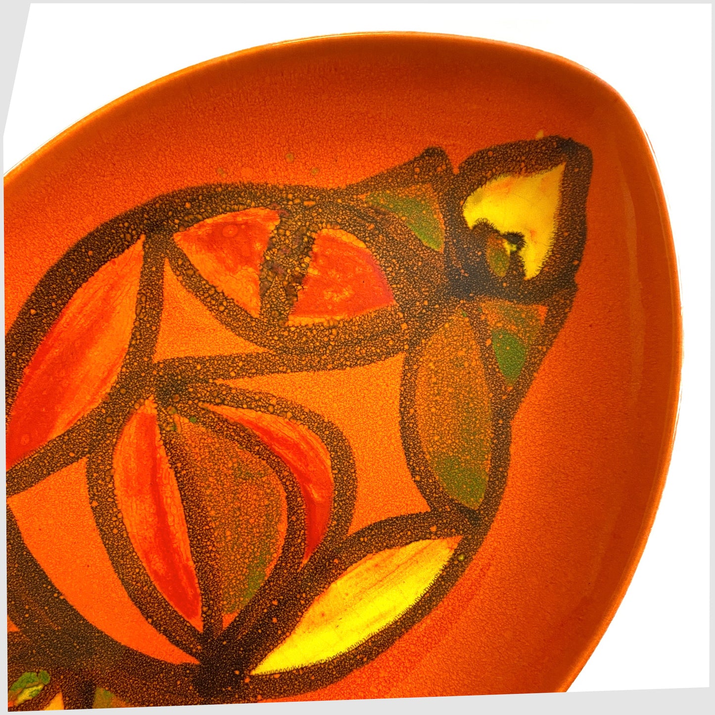 Close up of the Poole Pottery Delphis Teardrop Dish by Anita Lawrence in an orange glaze with fluid forms of red, yellow and green