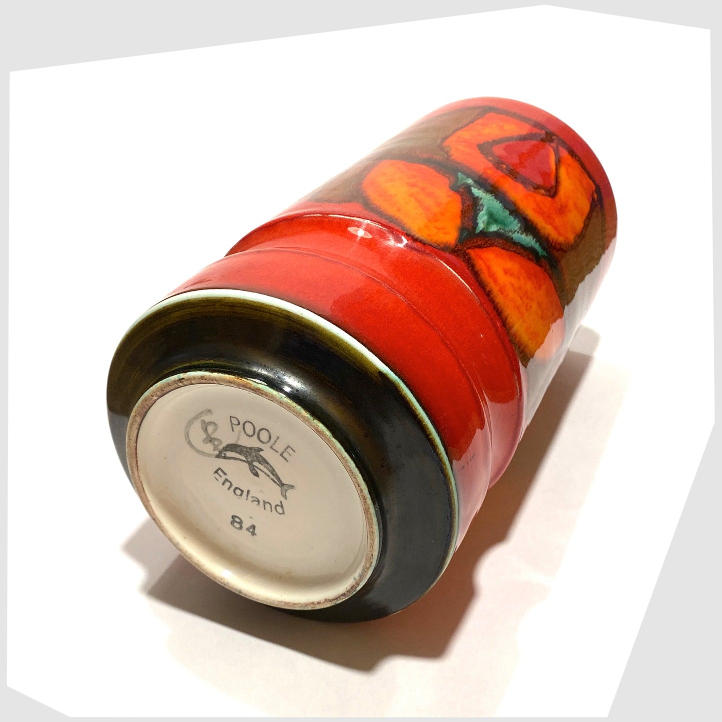 base of the Poole Pottery cylinder vase, shape 84, in a red, green and orange Delphis glaze by Cynthia Bennett