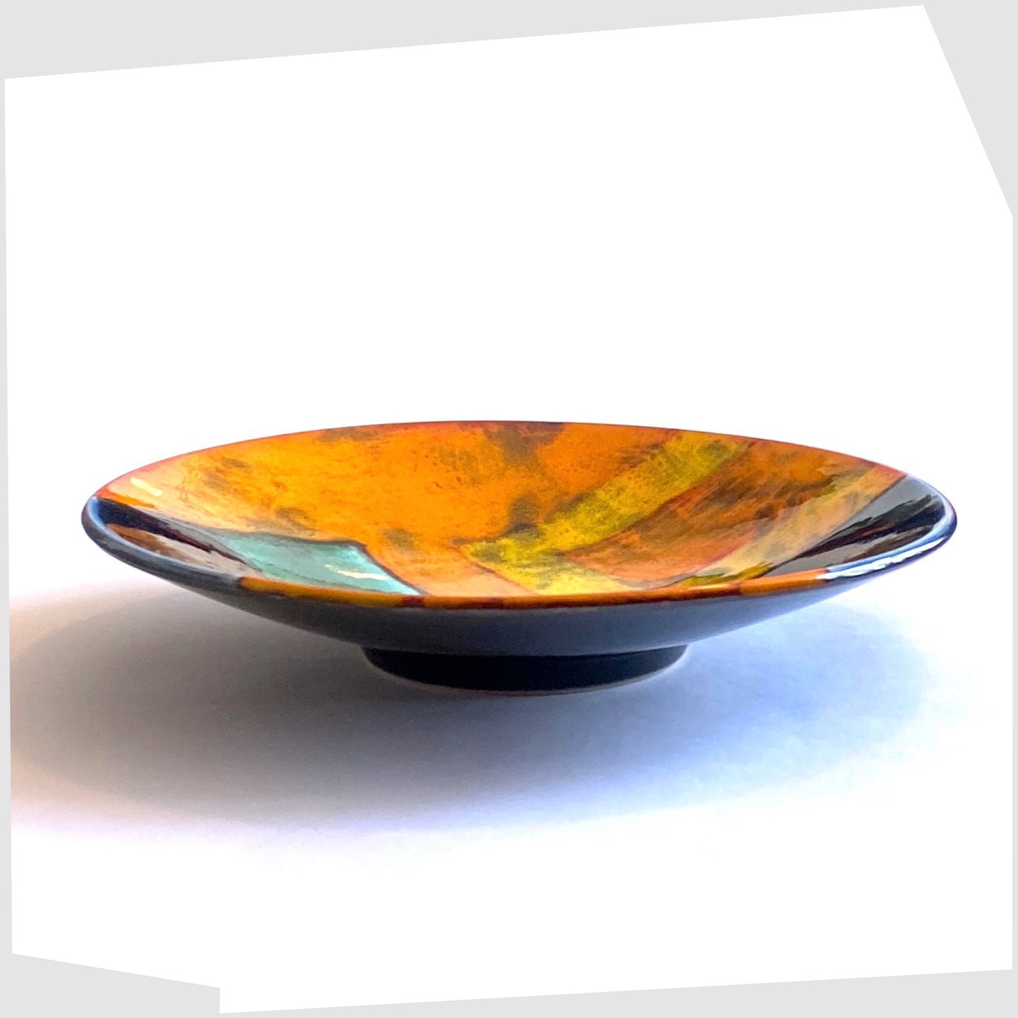 side profile of the poole pottery gemstones dish glazed in squares of orange, yellow, blue and green glaze