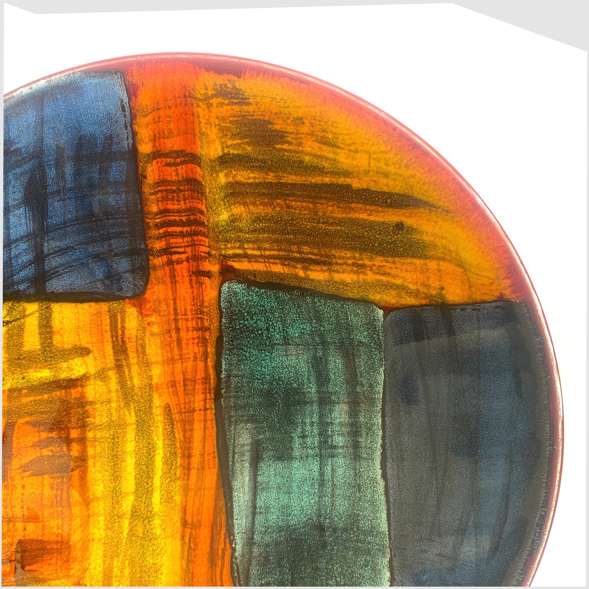 detail of the poole pottery gemstones dish glazed in an artistic pattern of orange, red, blue and green