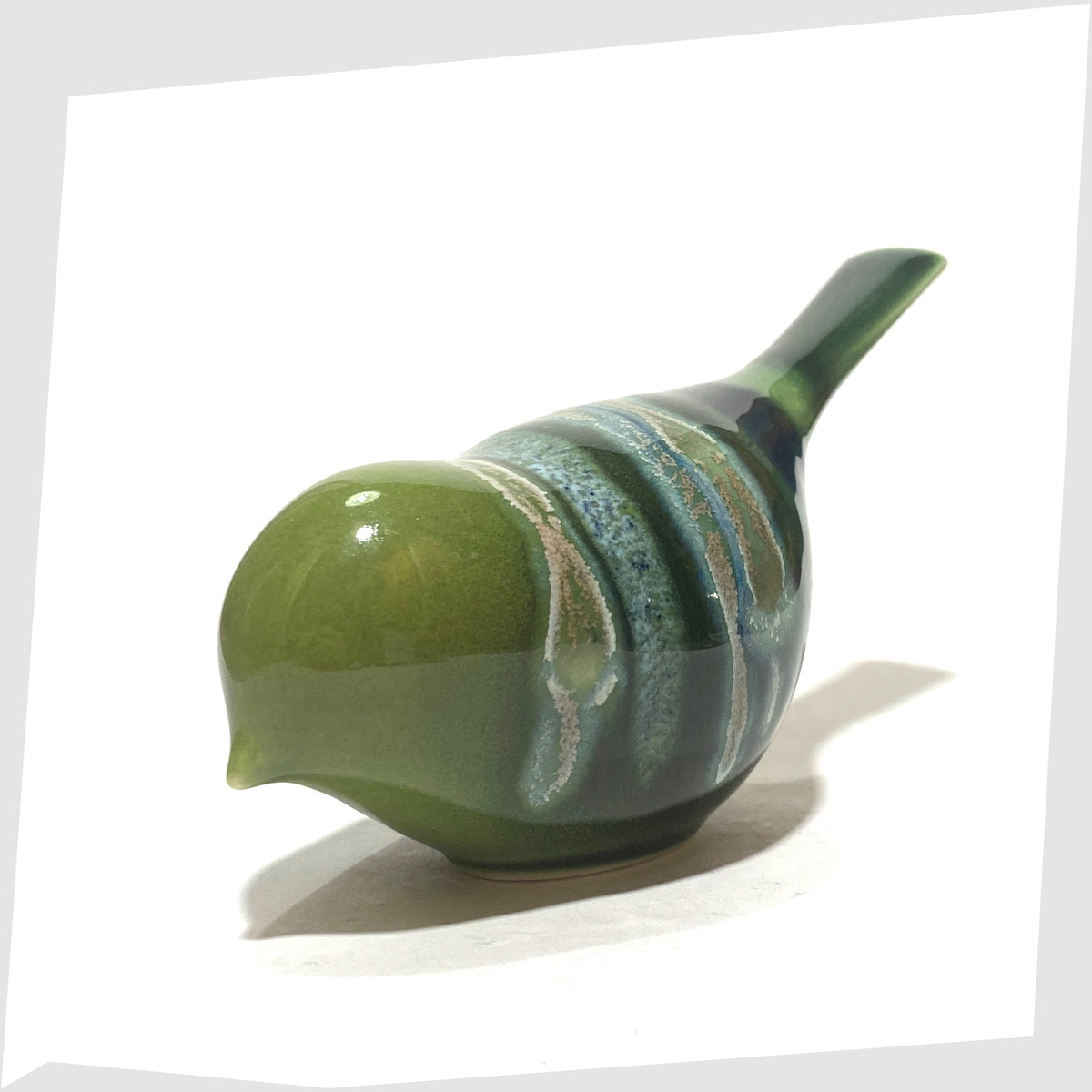 Front of the Poole Pottery Pecking Bird Figurine in Maya glaze of green, blue and grey, shown on a white background