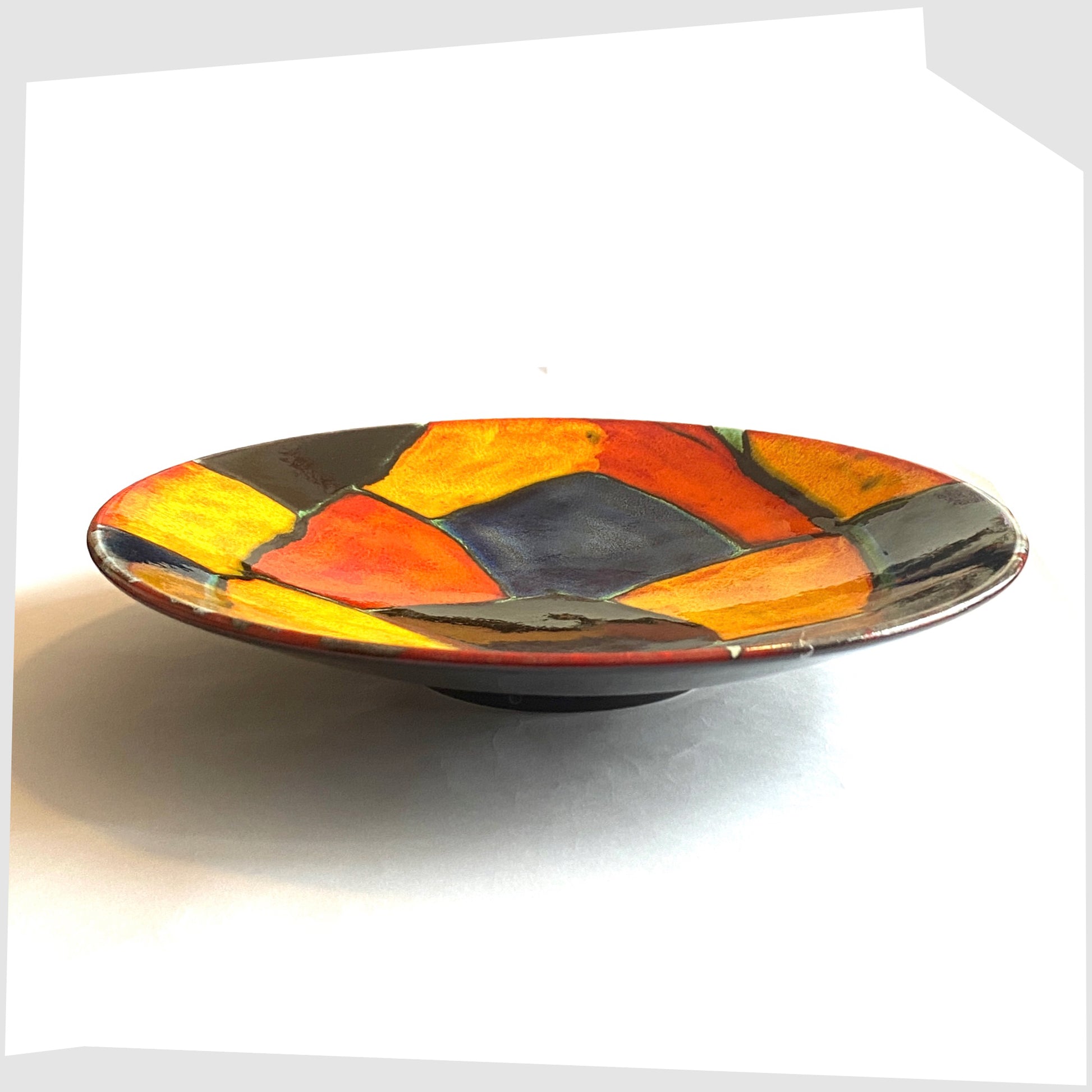 side profile of the Poole Pottery Mosaic Dish glazed in a multicoloured design of red, orange, black and blue forms
