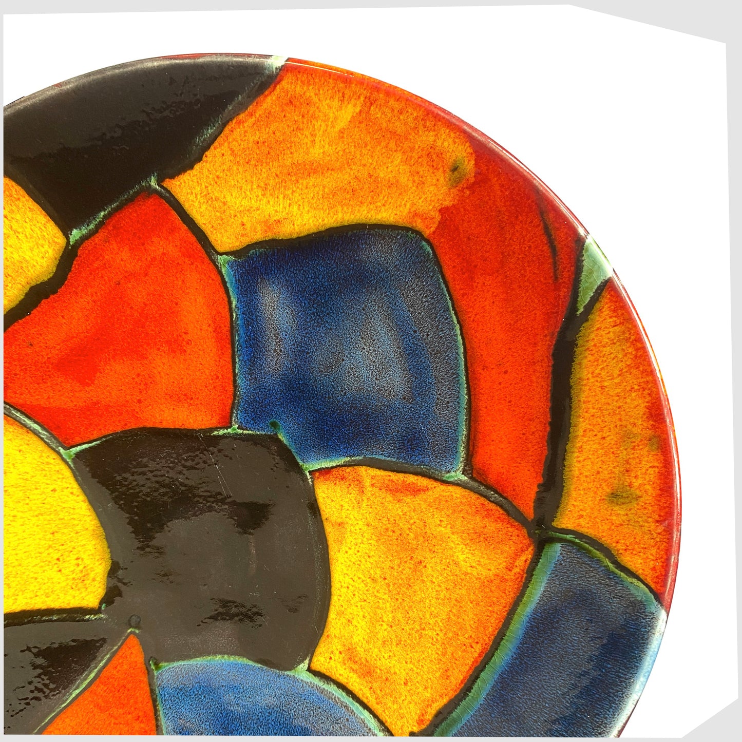 close up of the Poole Pottery Mosaic Dish glazed in a multicoloured design of red, orange, black and blue forms