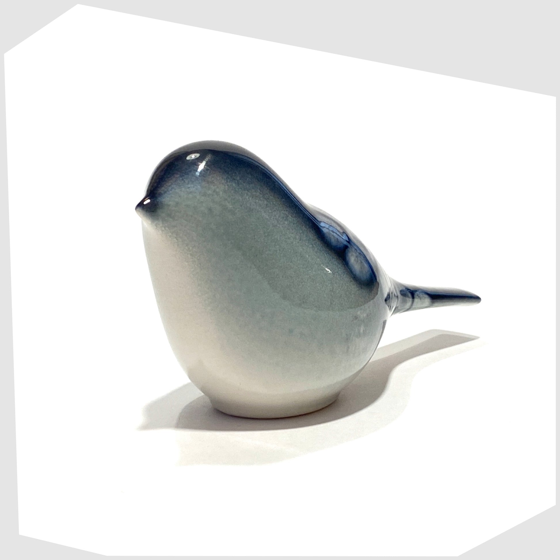front of the poole pottery perching bird ornament in ocean glaze of blue and white