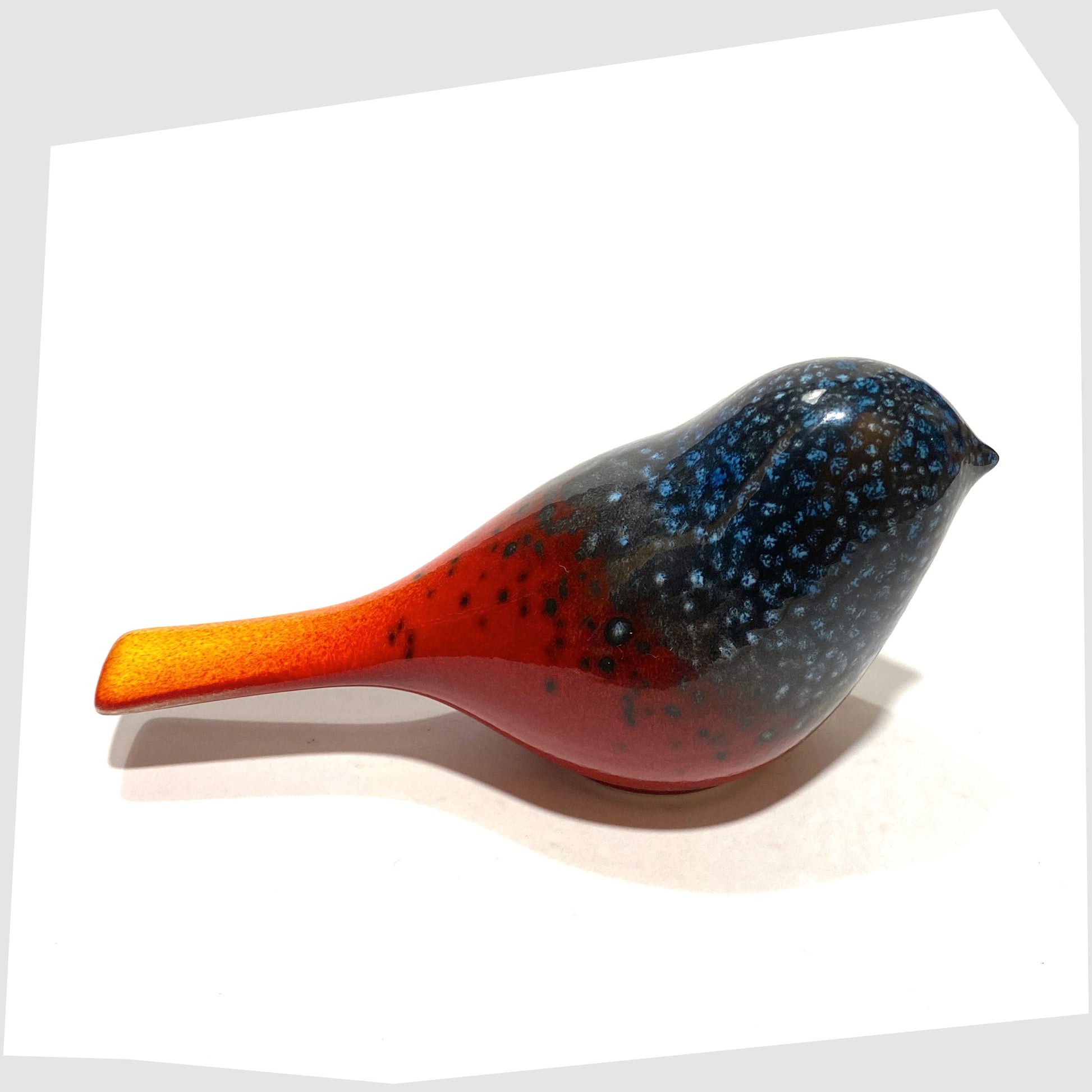 top view of the Poole Pottery Perching Bird in Flare glaze, designed by Alan Clarke, in rich red with black and blue speckles