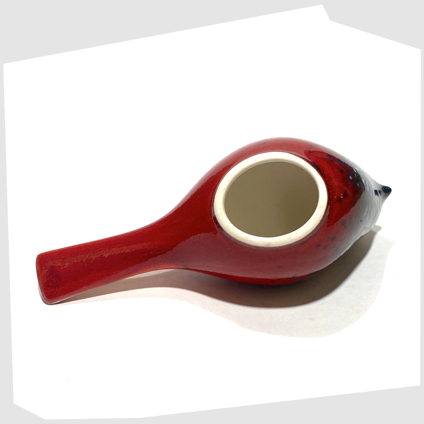 underneath of the Poole Pottery Perching Bird in Flare glaze, designed by Alan Clarke, in rich red with black and blue speckles