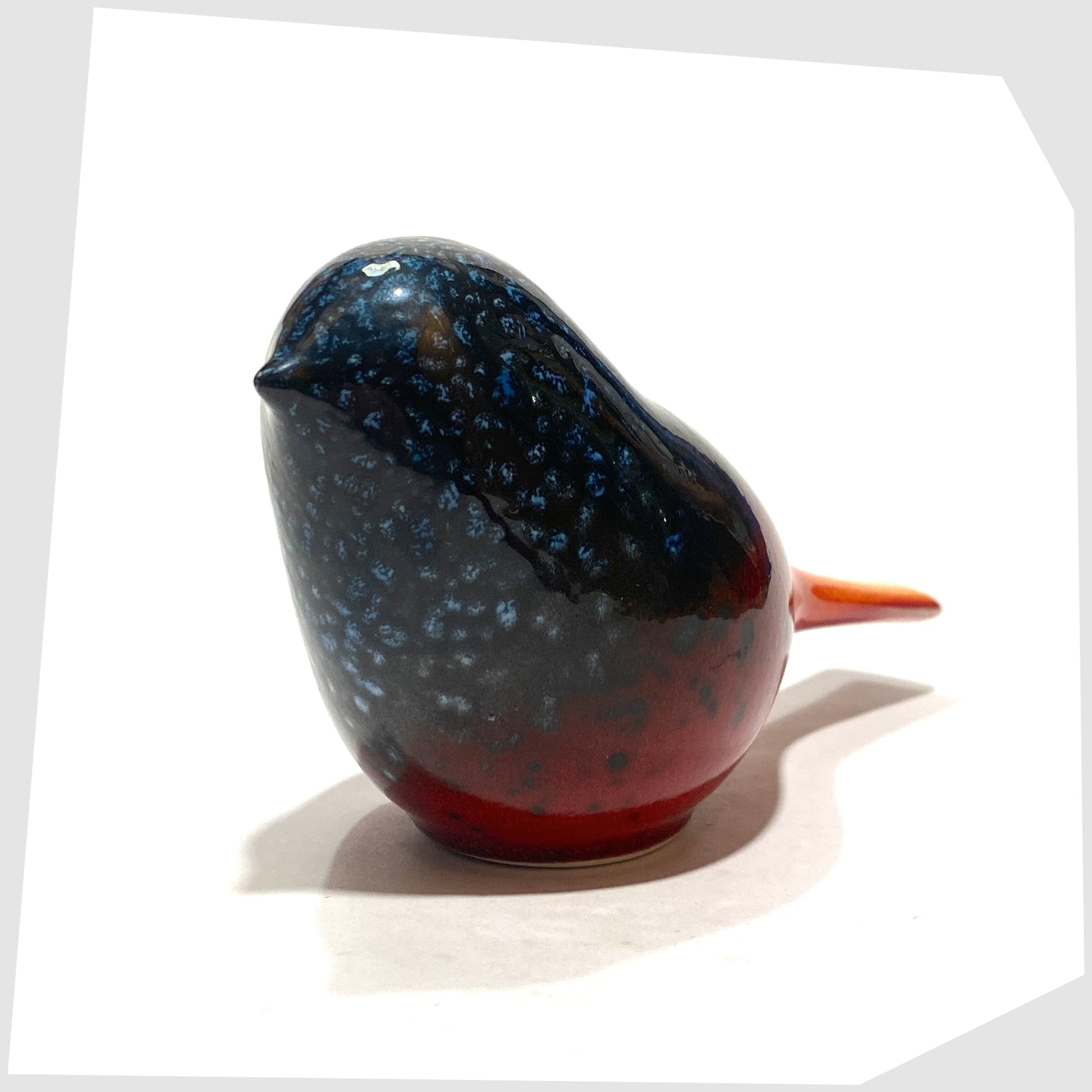 Vintage Poole Pottery Perching Bird in Flare glaze, designed by Alan Clarke, in rich red with black and blue speckles