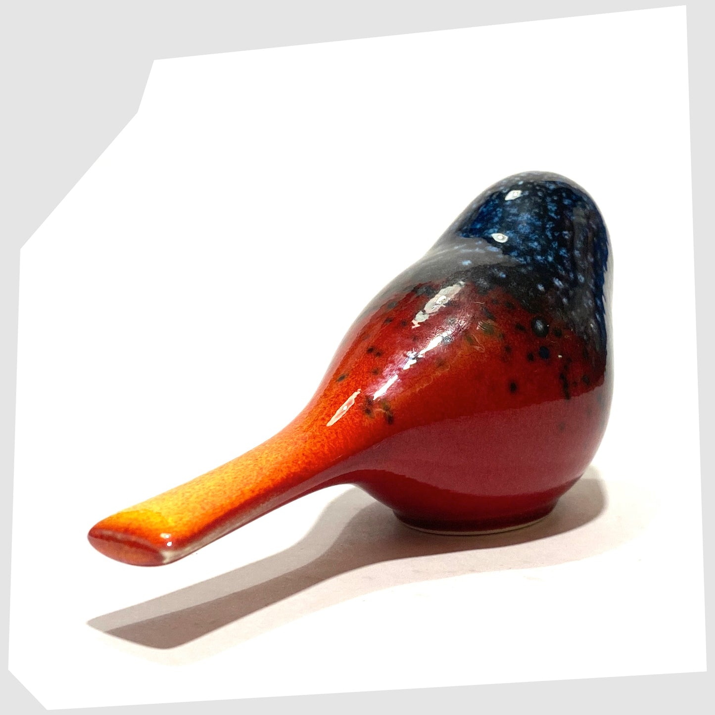 rear tail of the Poole Pottery Perching Bird in Flare glaze, designed by Alan Clarke, in rich red with black and blue speckles
