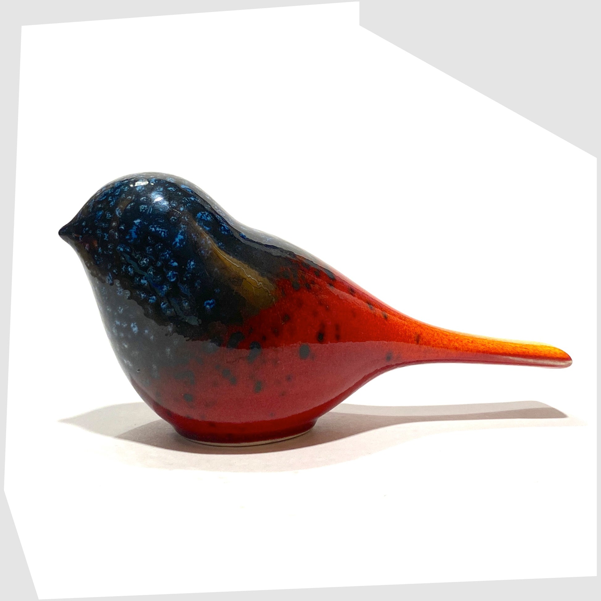 Poole Pottery Perching Bird in Flare glaze, designed by Alan Clarke, in rich red with black and blue speckles