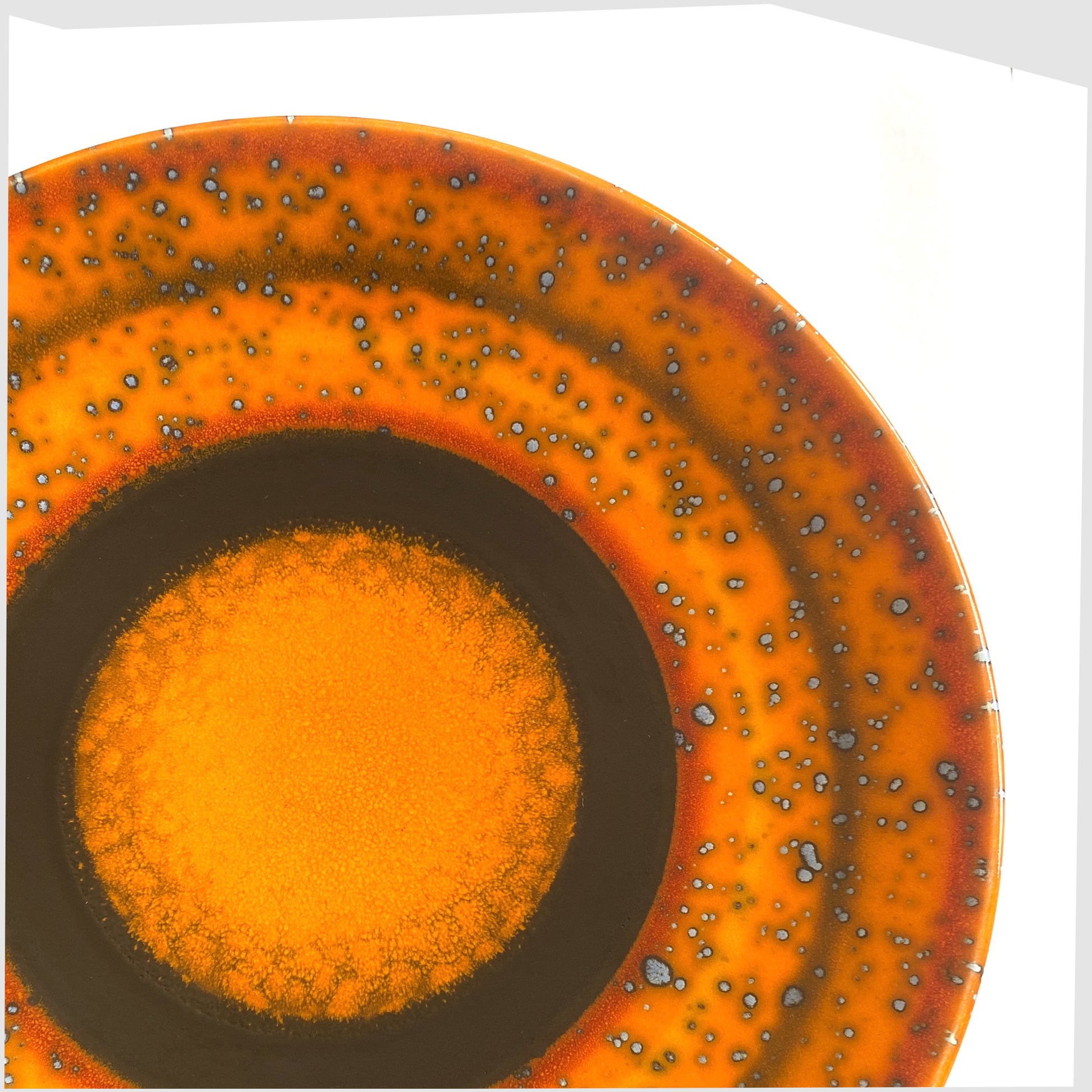 poole pottery decorative Saturn plate in a vibrant orange with rings of black glaze, designed by Alan Clarke to mark the alignment of the planets in 2000.