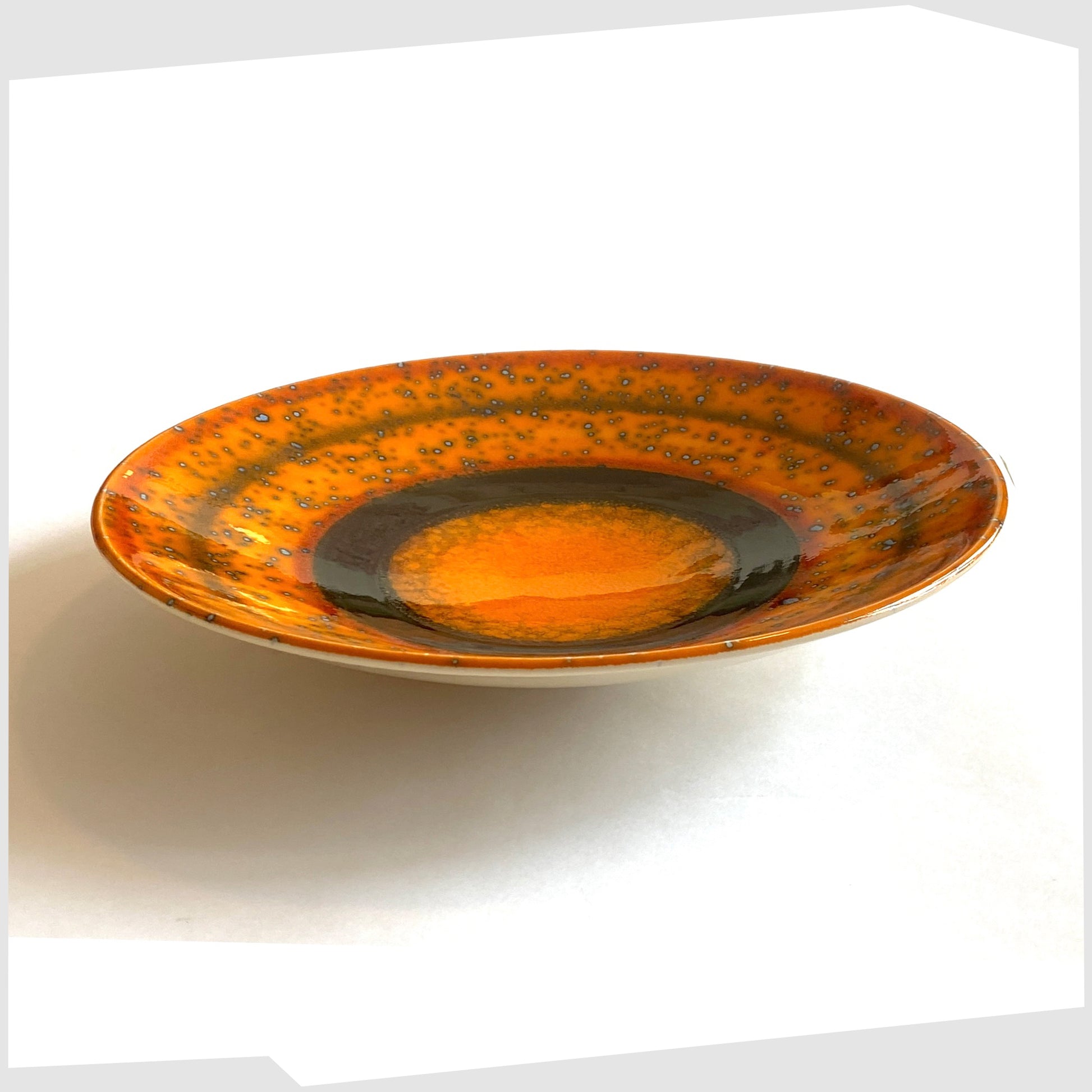 orange and black poole pottery decorative Saturn plate designed by Alan Clarke to mark the alignment of the planets in 2000.