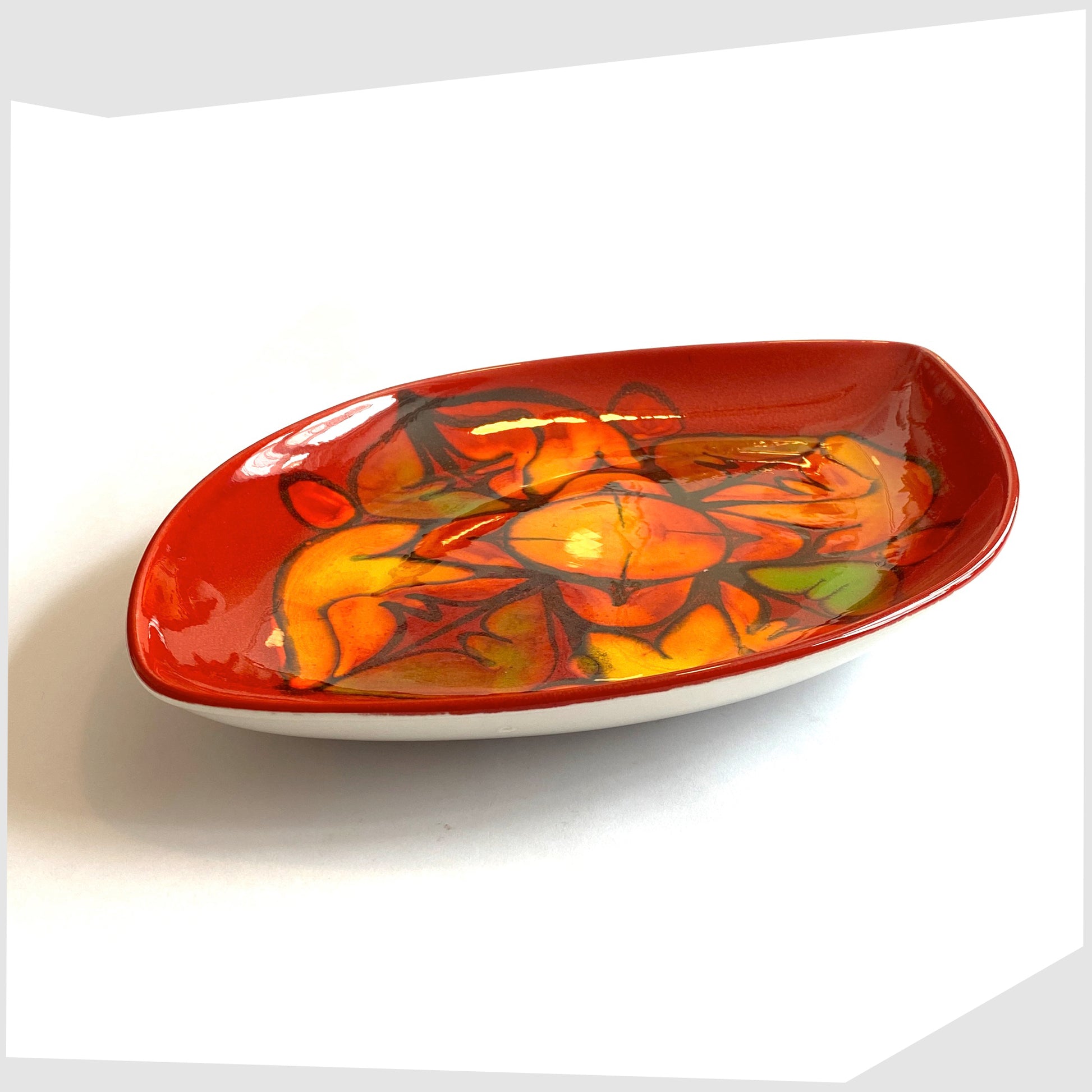 vintage poole pottery teardrop-shaped dish, shape 91, in vivid red glaze with orange and green forms