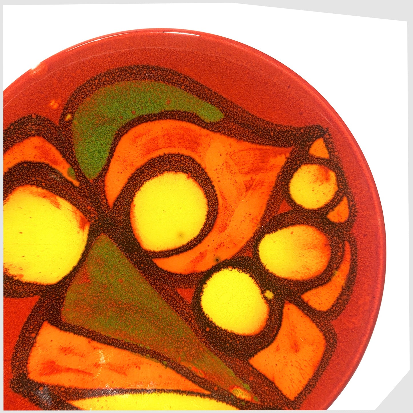 close up of the Poole Pottery Delphis Pin Dish, by Gillian Taylor, finished in a rich red with free forms of orange and green