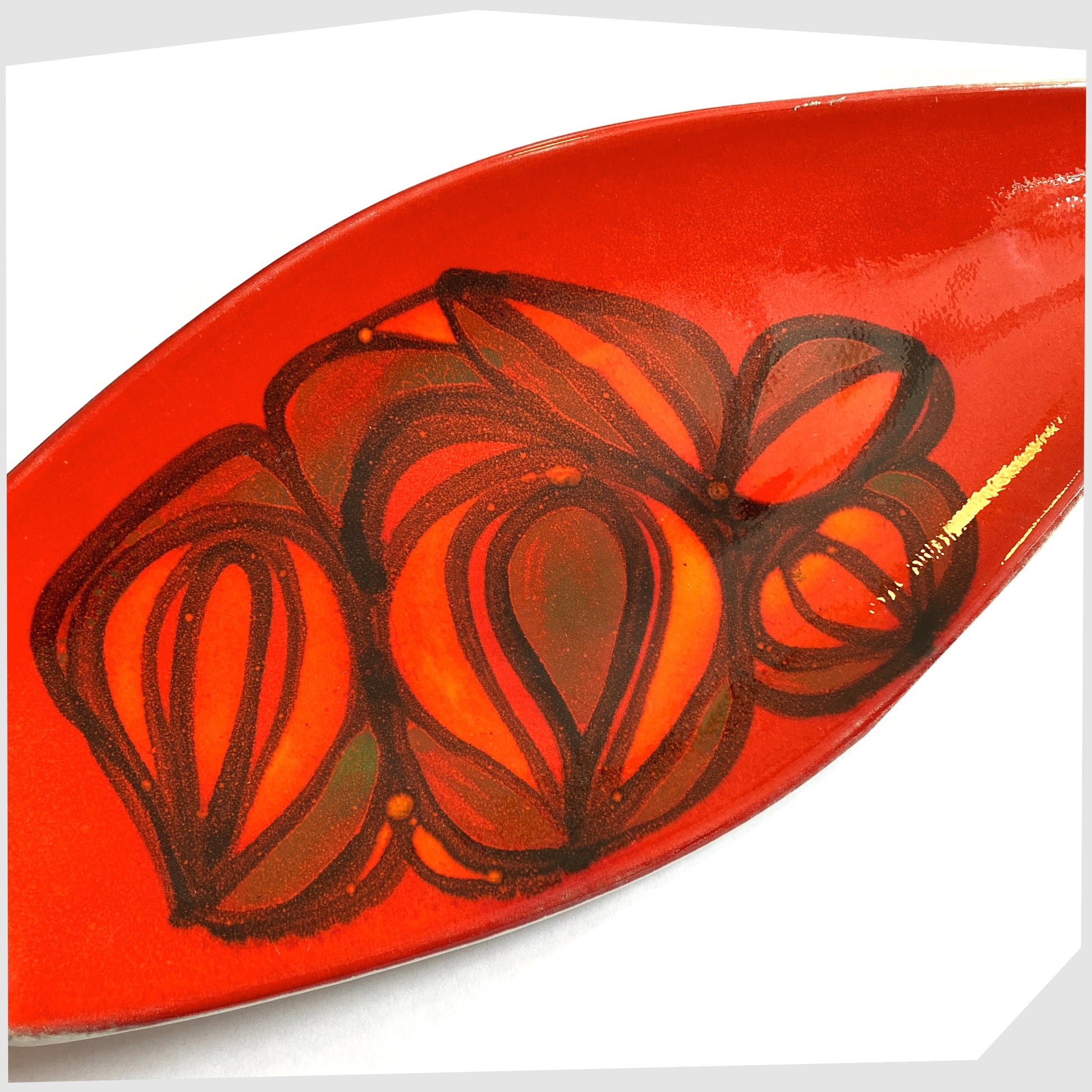 close up of the vintage Poole Pottery Spear Dish in a red Delphis glaze with free-form shapes in orange and green