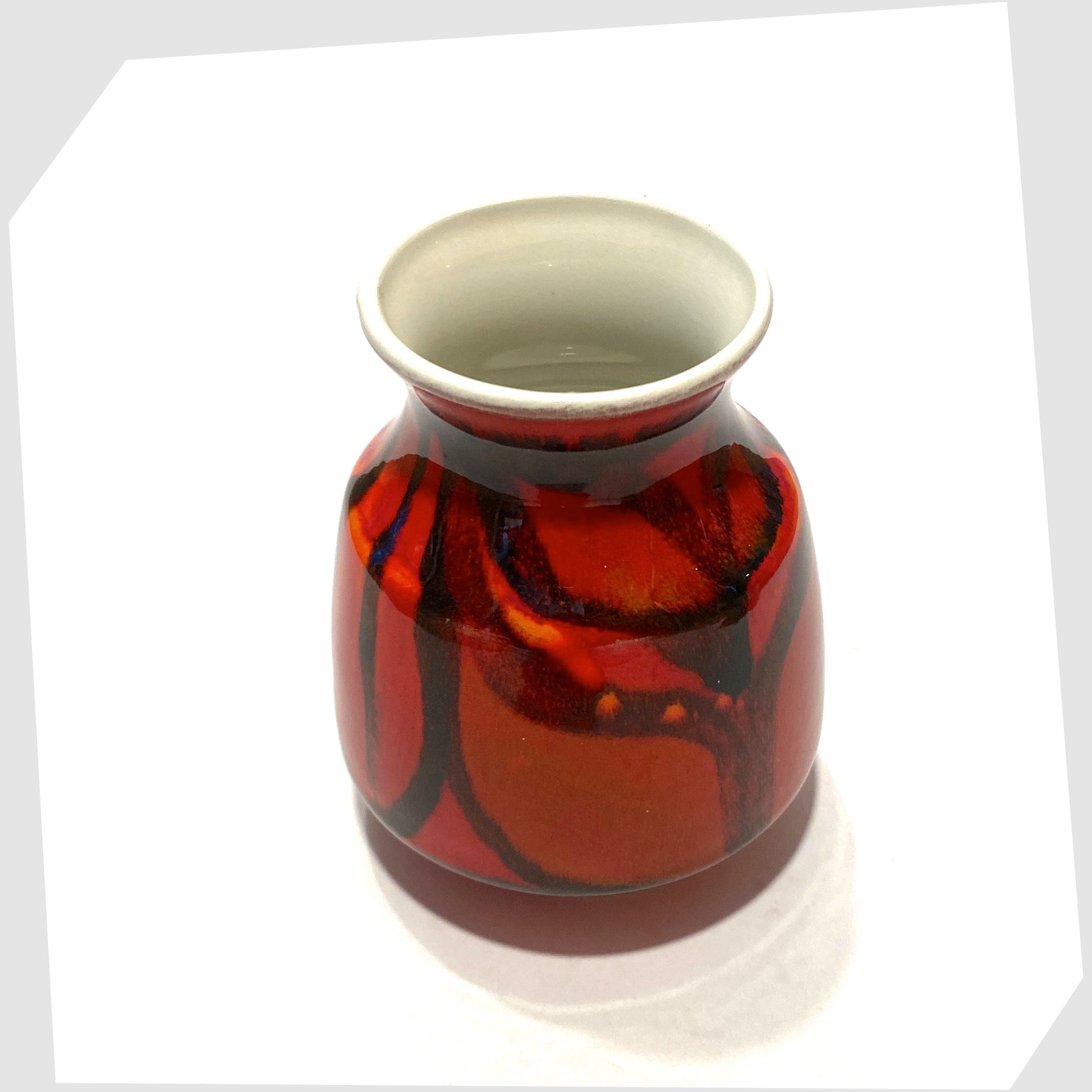 top rim of the Poole Pottery Delphis Vase, Shape 31, by Lynn Gregory finished in a red glaze with fluid forms of green and orange