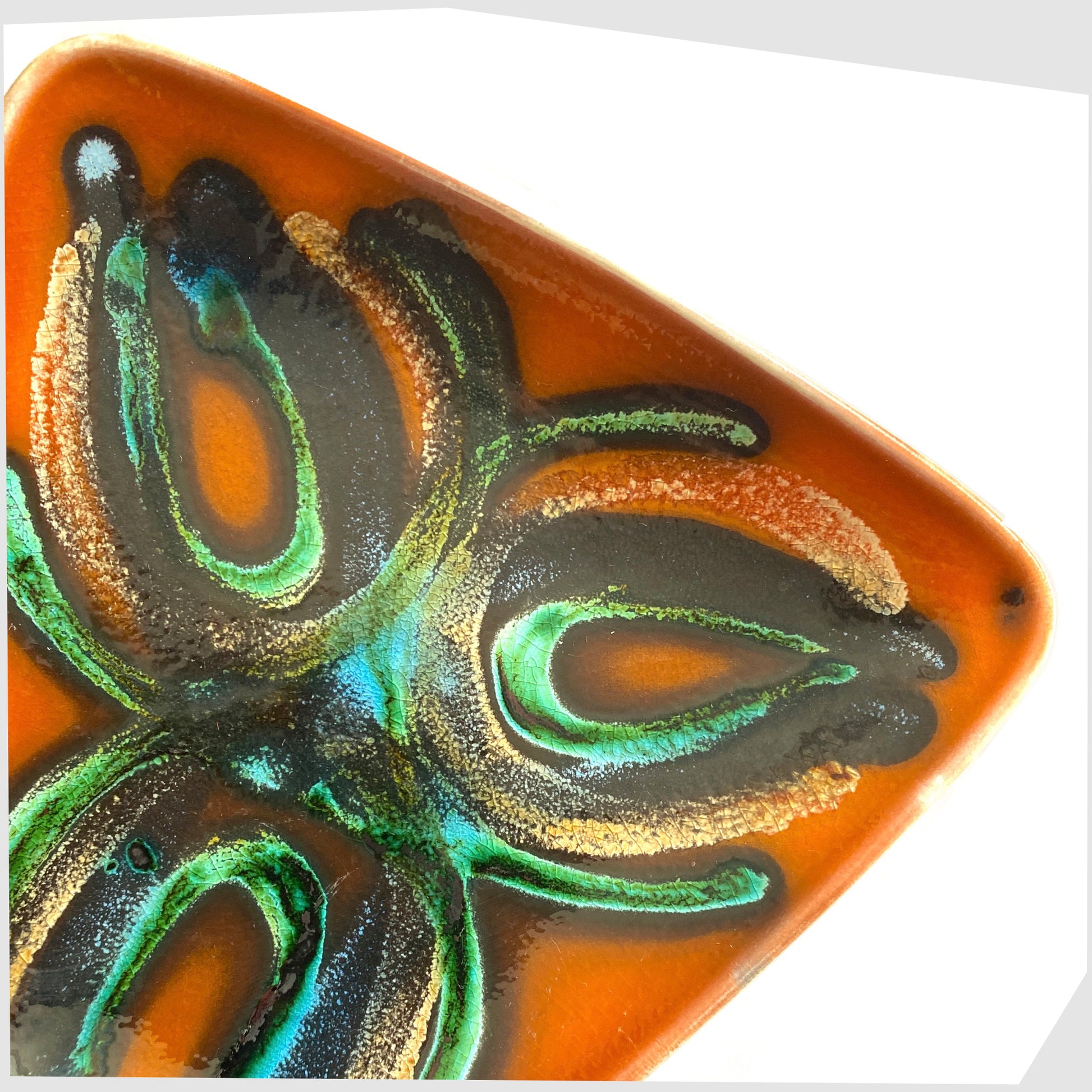 close up of the Poole Pottery Dish, Shape 81, by Particia Wells finished in a vibrant orange with artistic lines of black and green glaze