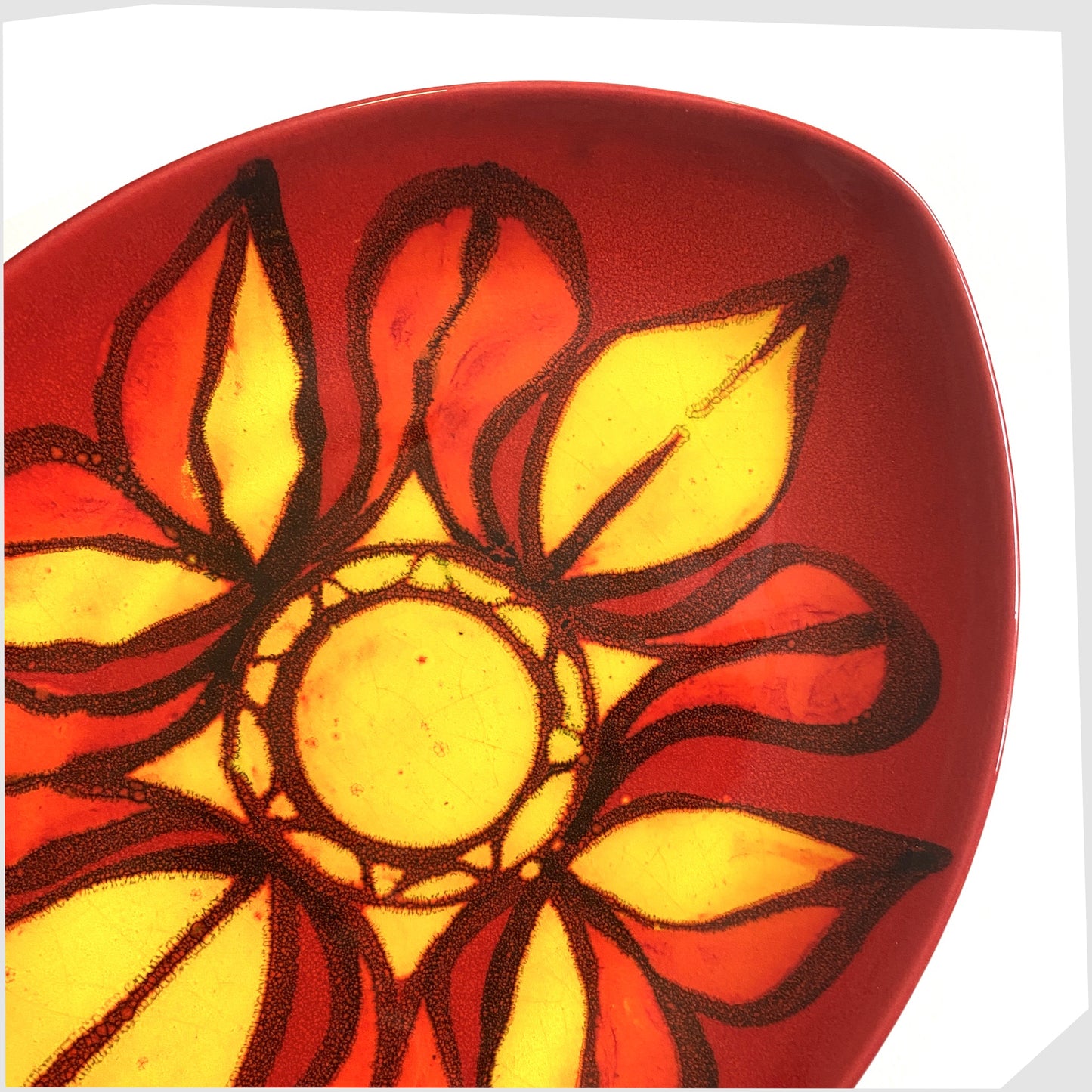 close up of the Poole Pottery Delphis Teardrop dish in vivid red and yellow glaze, created by Janet Laird