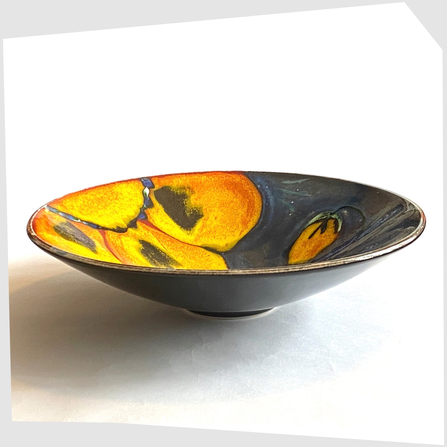 side profile of the Poole Pottery Wild Poppy Dish, designed by Anita Harris, glazed in vivid blue with yellow poppy petals