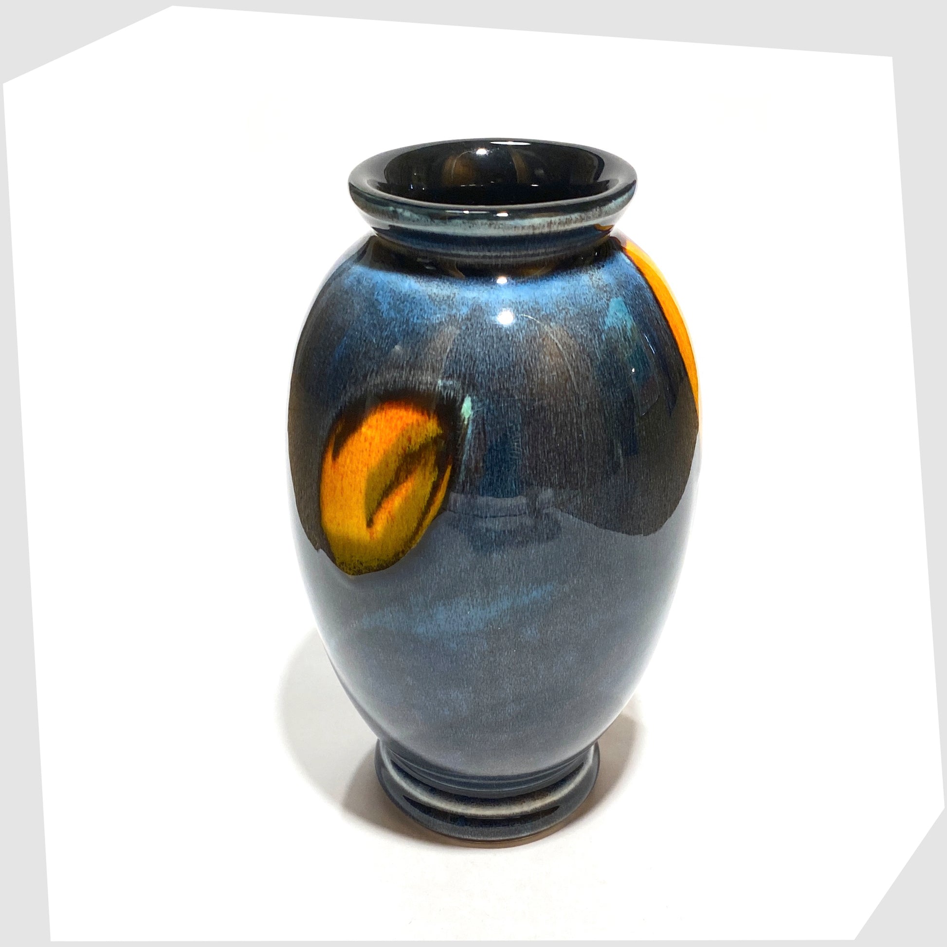 rear of the Poole Pottery Wild Poppy Vase in a marbled blue glaze with vivid yellow wild poppy flower