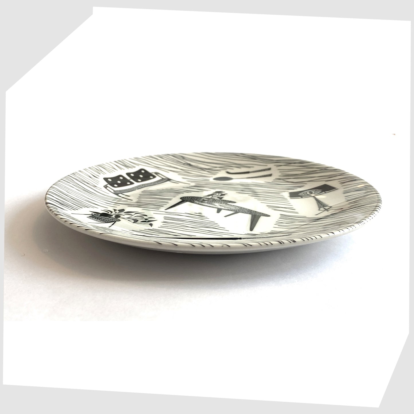 vintage homemaker side plate with iconic black and white print of chairs, tables, lamps etc