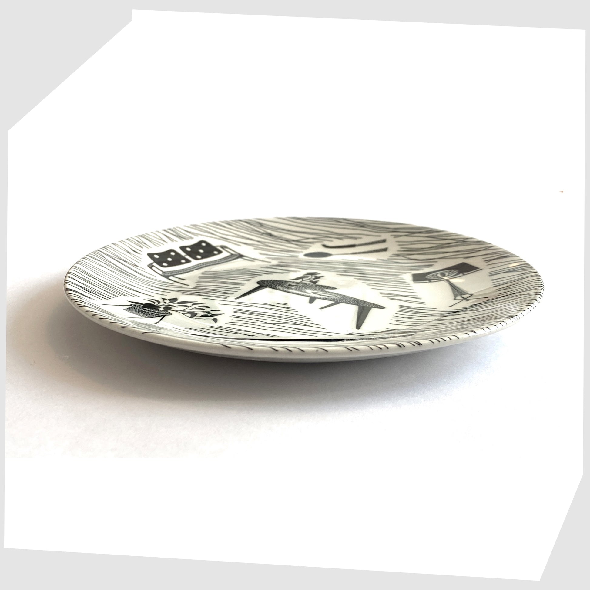 vintage homemaker side plate with iconic black and white print of chairs, tables, lamps etc