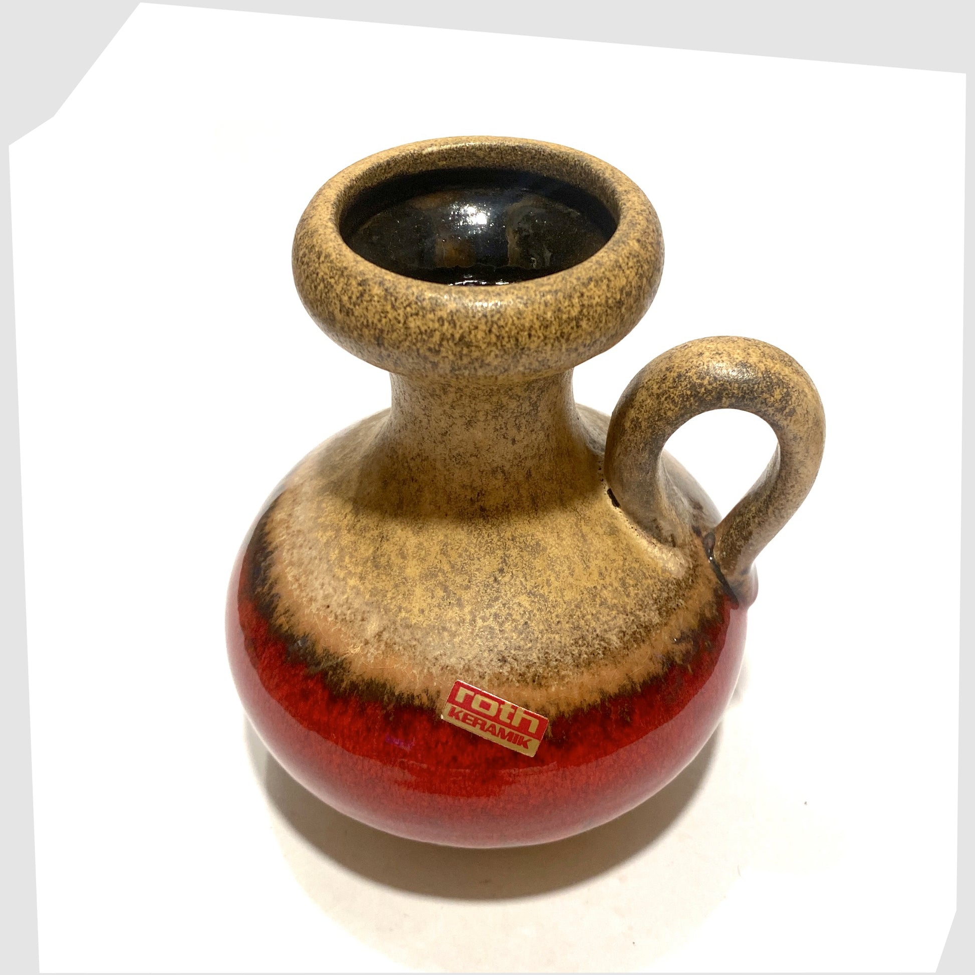 top rim of the roth keramik vase with curved handle with a central stripe of volcanic red glaze