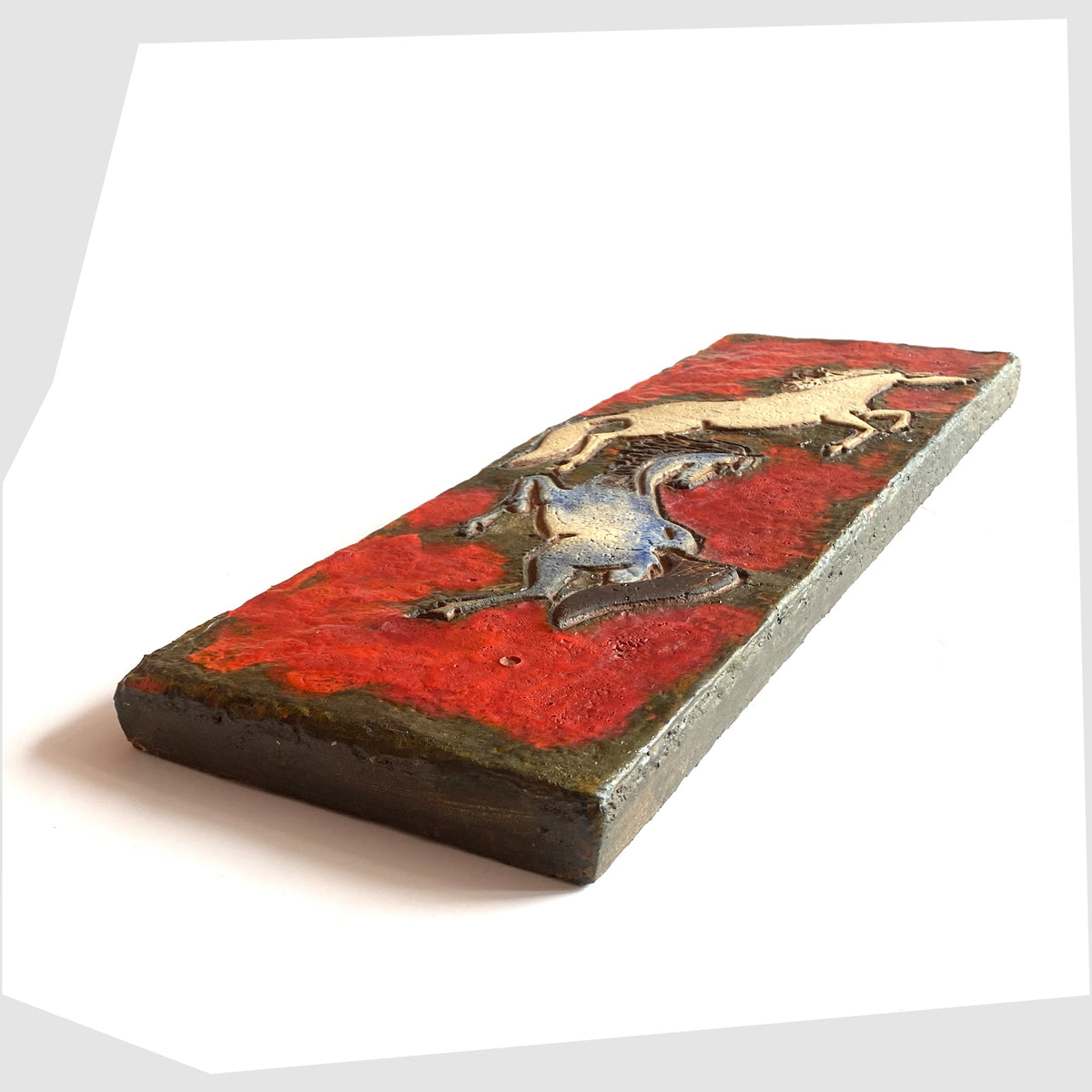 Side profile of the Ruscha Keramik Wall Plaque, designed by Adele Bolz, featuring a pair of horses on a red fat lava glaze, shown on a white background