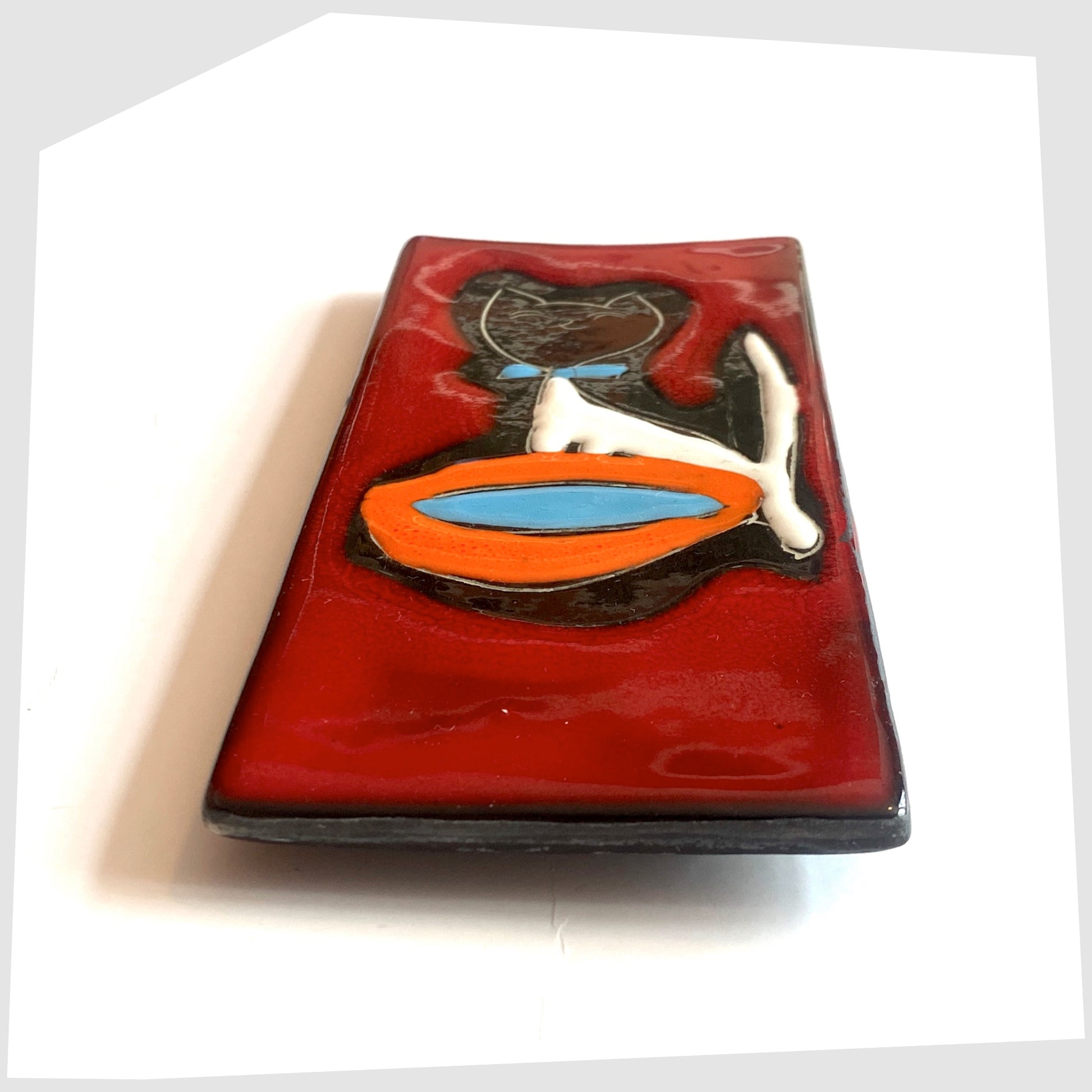 Side profile of the San Marino Pottery Wall Plaque featuring a black cat with blue bow tie and orange water bowl on a vibrant red glaze, shown on a white background