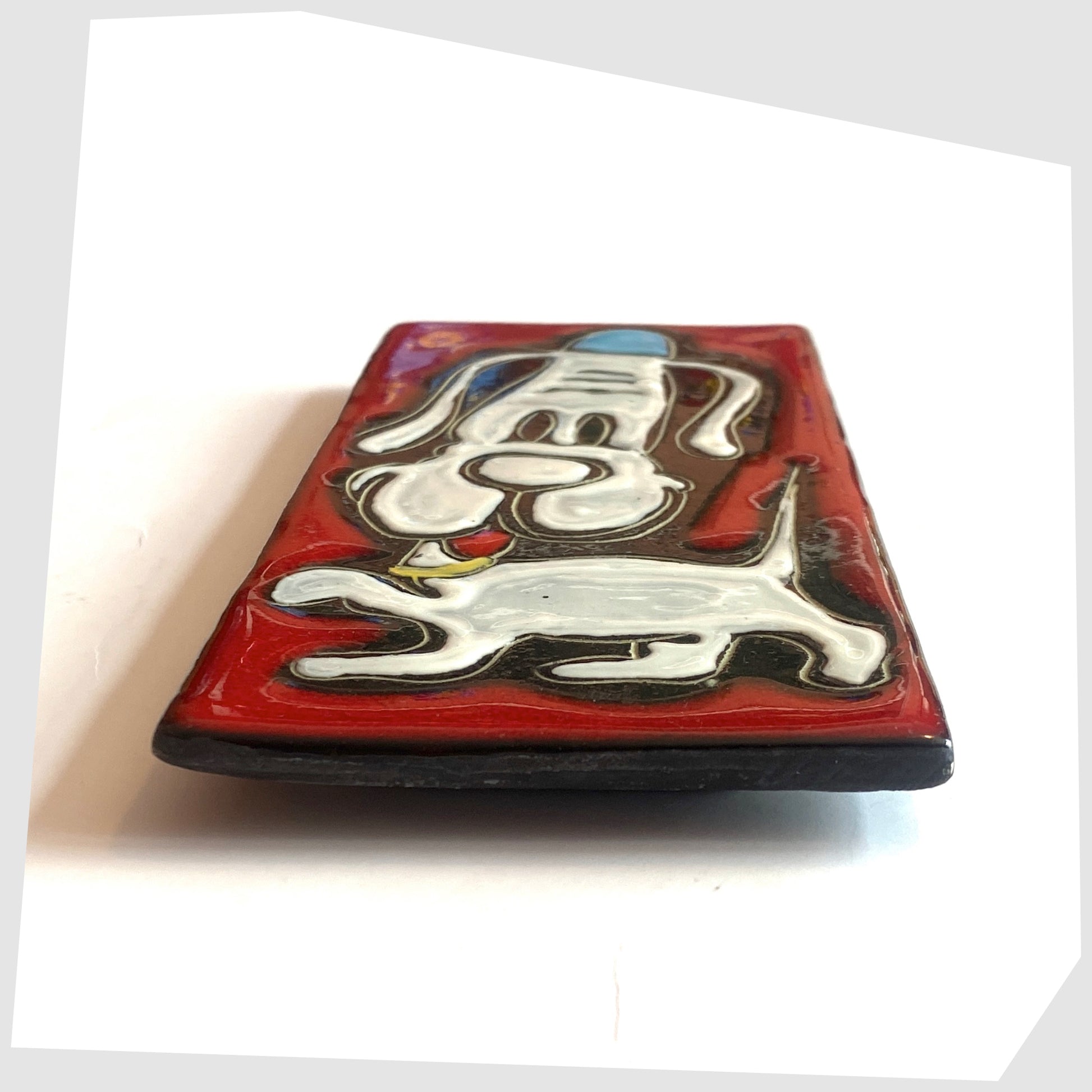 Side profile of the San Marino Pottery Wall Plaque featuring a white dog in a blue hat on a vibrant red glaze, shown on a white background