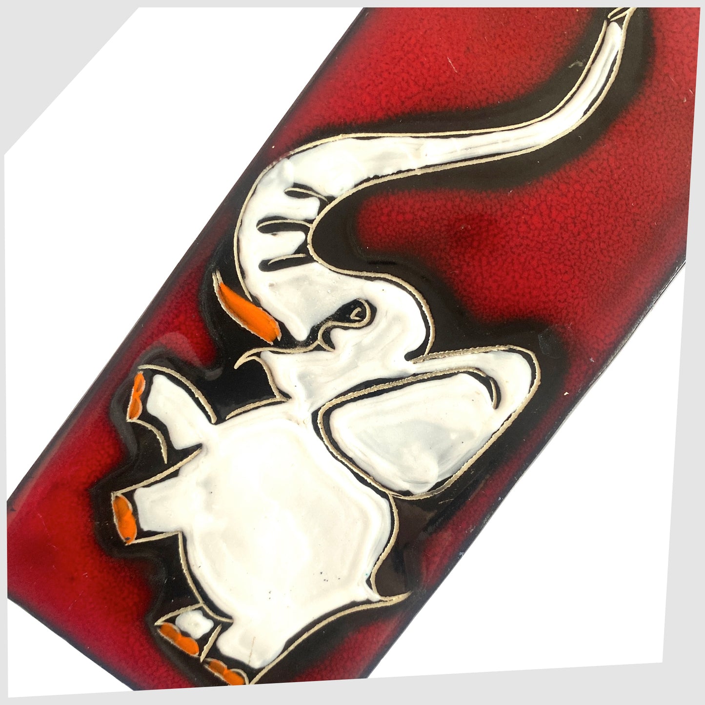 Close up of the San Marino Pottery Wall Plaque featuring a white elephant with pops of orange on a vivid red glaze, shown on a white background