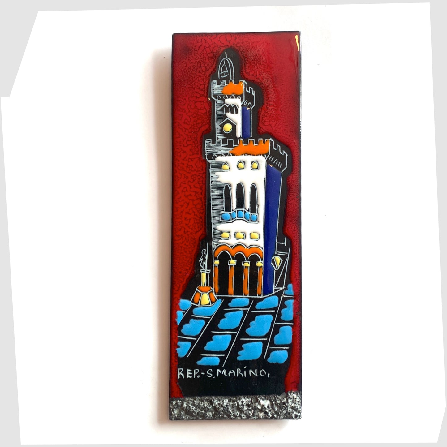 San Marino Pottery Wall Plaque featuring a town scene in white, orange and blue on a vibrant red tile, shown on a white background