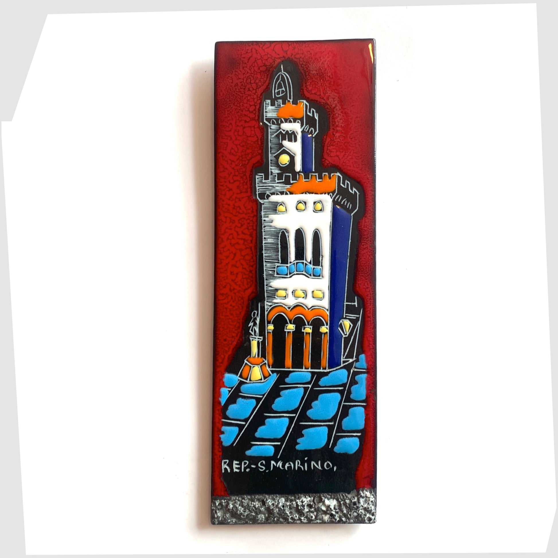 San Marino Pottery Wall Plaque featuring a town scene in white, orange and blue on a vibrant red tile, shown on a white background