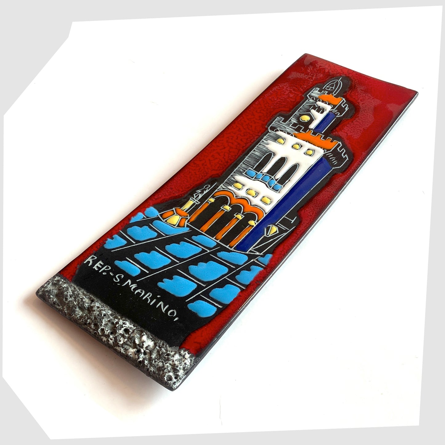Vintage San Marino Pottery Wall Plaque featuring a town scene in white, orange and blue on a vibrant red tile, shown on a white background