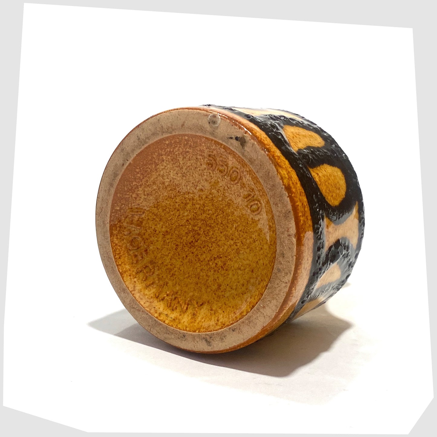 Base of the Scheurich Keramik 550-10 Vase in an amber glaze with black fat lava circles and white swirls, shown on a white background