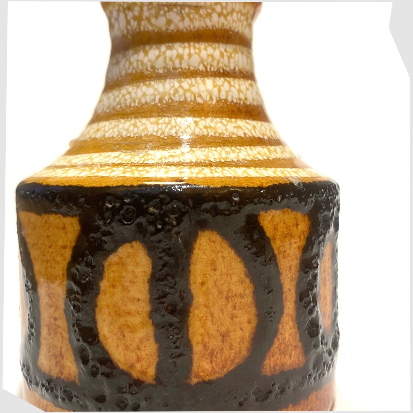 Close up of the Scheurich Keramik 550-10 Vase in an amber glaze with black fat lava circles and white swirls, shown on a white background