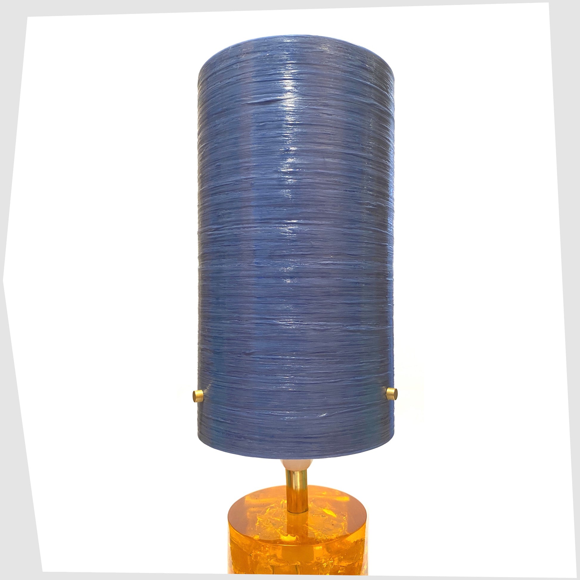 Royplast Spun Fibreglass Lampshade by By Royale in the blue colourway, shown on an orange Shattaline table lamp base