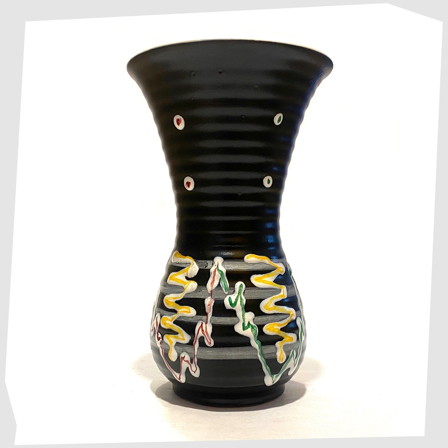 1960s West German Pottery Vase in black glaze with with artistic lines of yellow, green and red glaze, shown on a white background