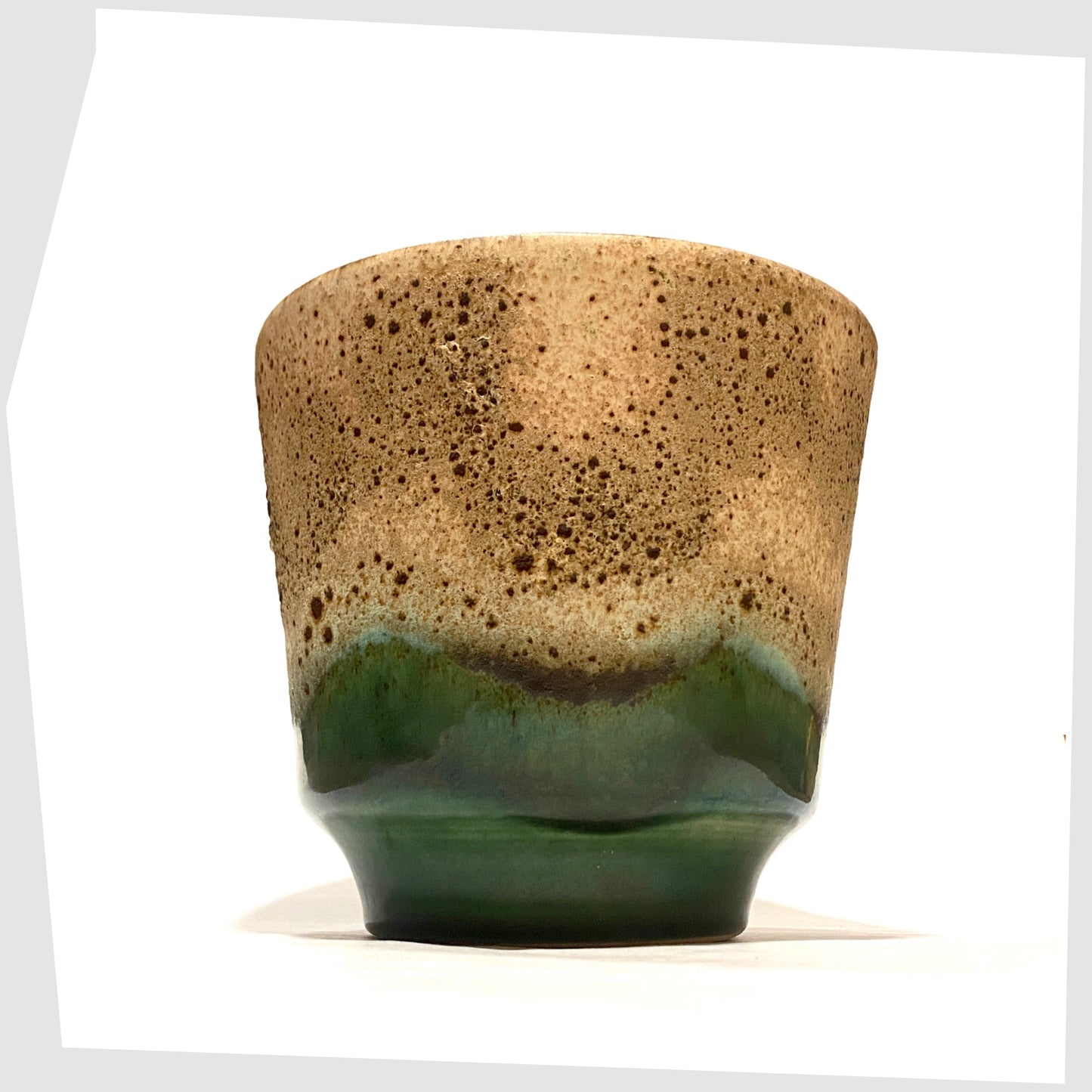 West German Pottery Planter finished in green glaze with cascading matte fat lava glaze, shown on a white background