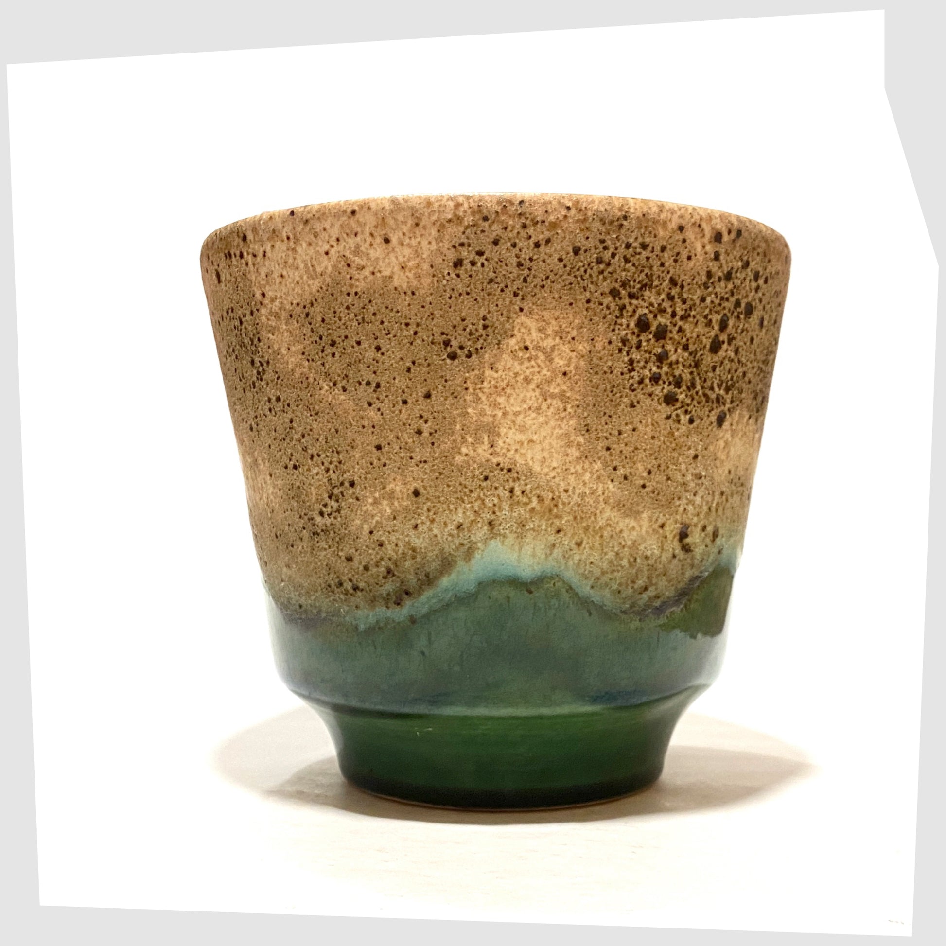 1970s West German Pottery Planter finished in green glaze with cascading matte fat lava glaze, shown on a white background