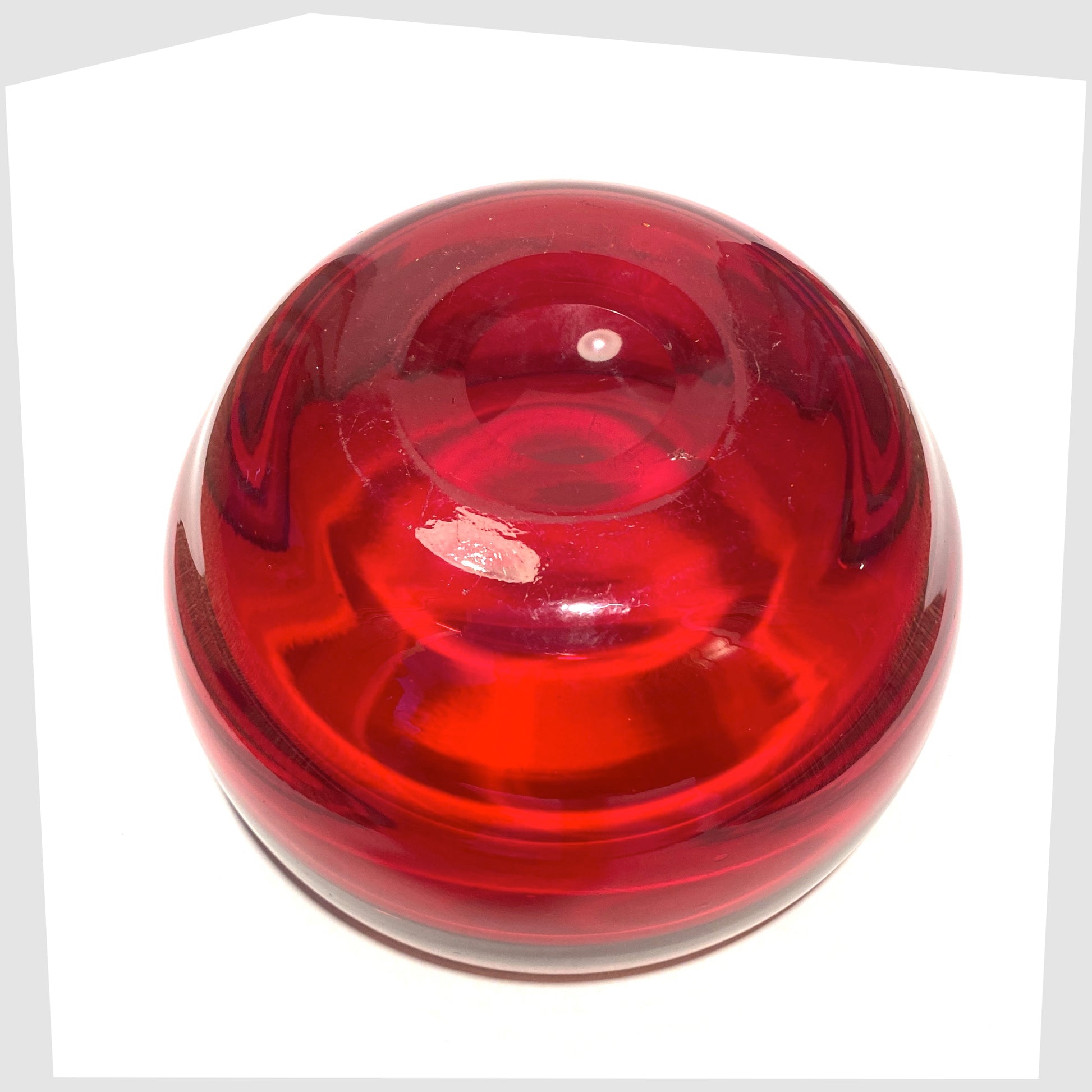 underside of the Whitefriars Glass Optical Bowl in ruby red glass, shown on a white background